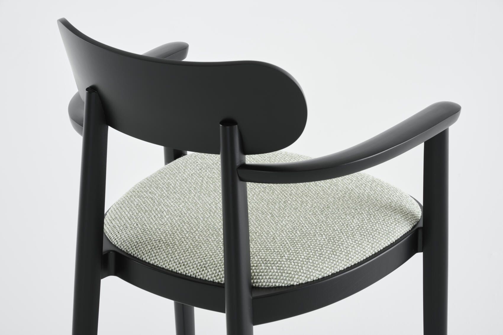 Detailaufnahme: Schwarzer 118 SPFV Holzstuhl mit Armlehnen und hellgrauem Stoffbezug von Thonet.