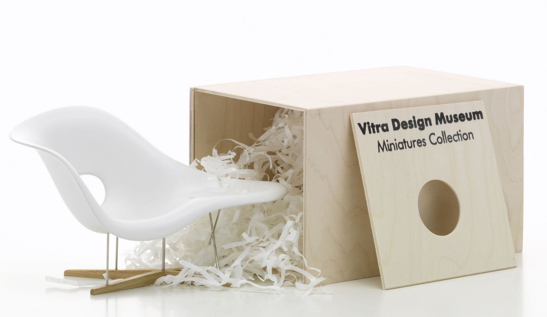 Weiße La Chaise Miniatur Liege von Vitra in einer Holzkiste mit Füllmaterial.