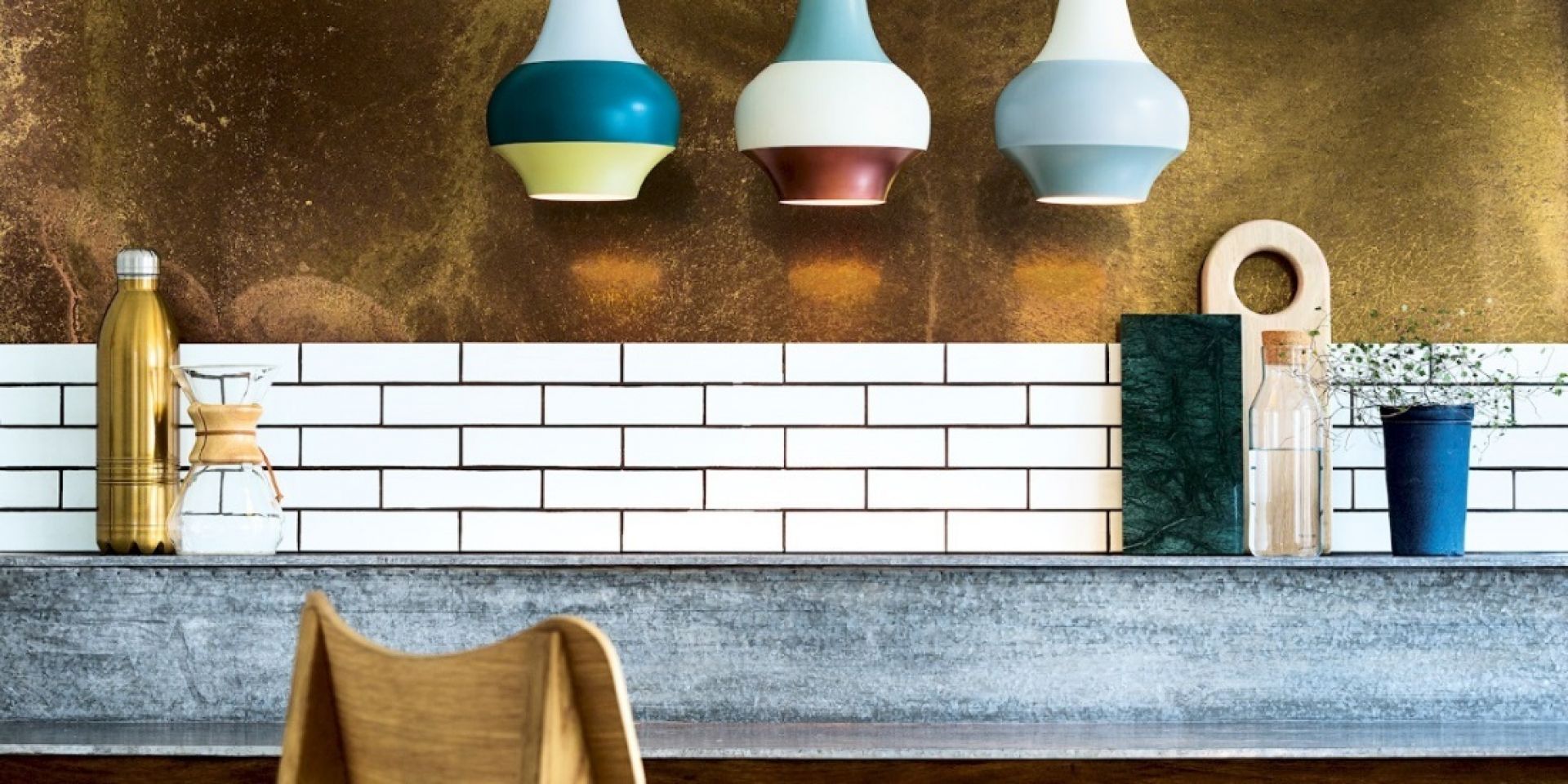 Drei farbige Cirque Pendelleuchten von Louis Poulsen über einer Küchentheke mit Accessoires.