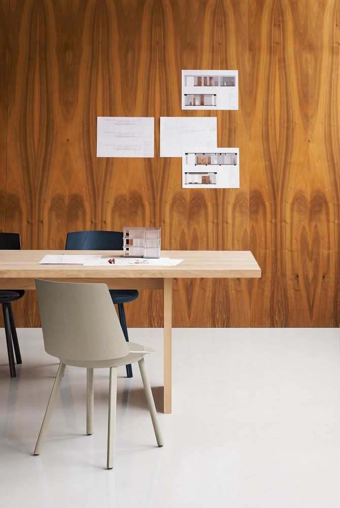 TA24 Ashida Tisch von e15: Rechteckiger Esstisch aus Massivholz mit Stühlen und Büroaccessoires.