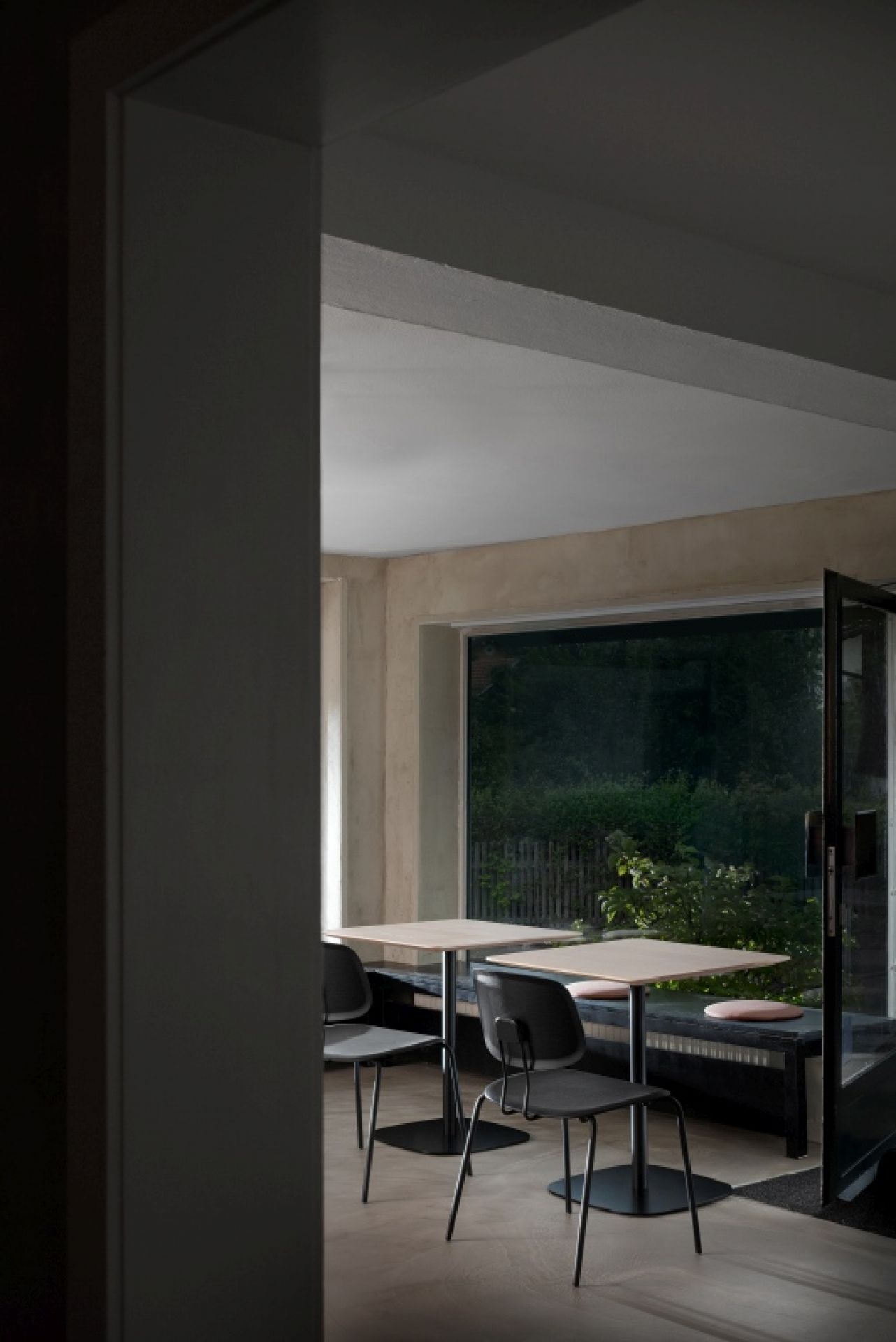 Zwei quadratische Vermu Esstische von Zeitraum mit schwarzen Stühlen in einem hellen Raum mit Fenster.