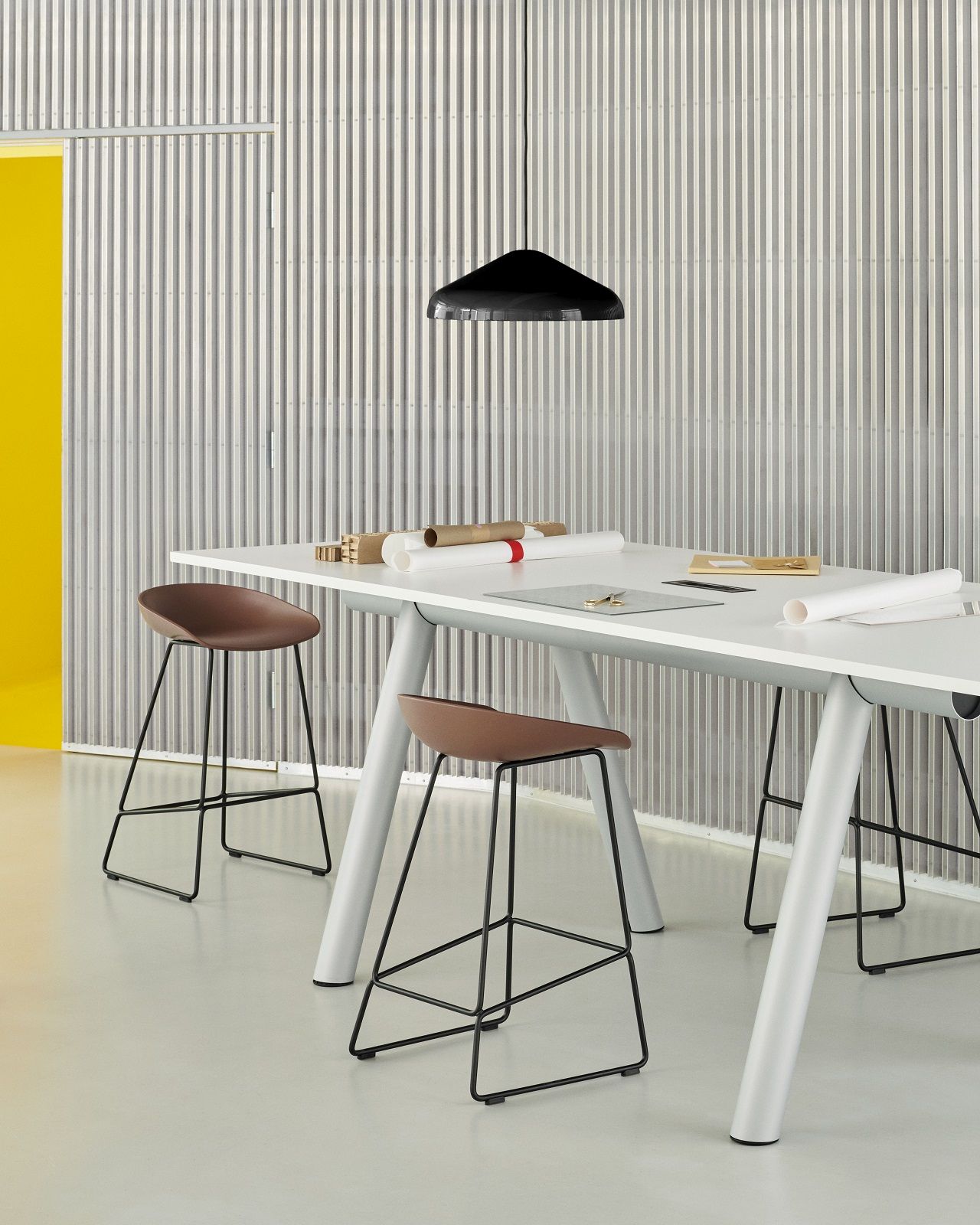 Weißer Hay Boa Table mit braunen Hockern und Papieren, ideal für Büro oder Homeoffice.