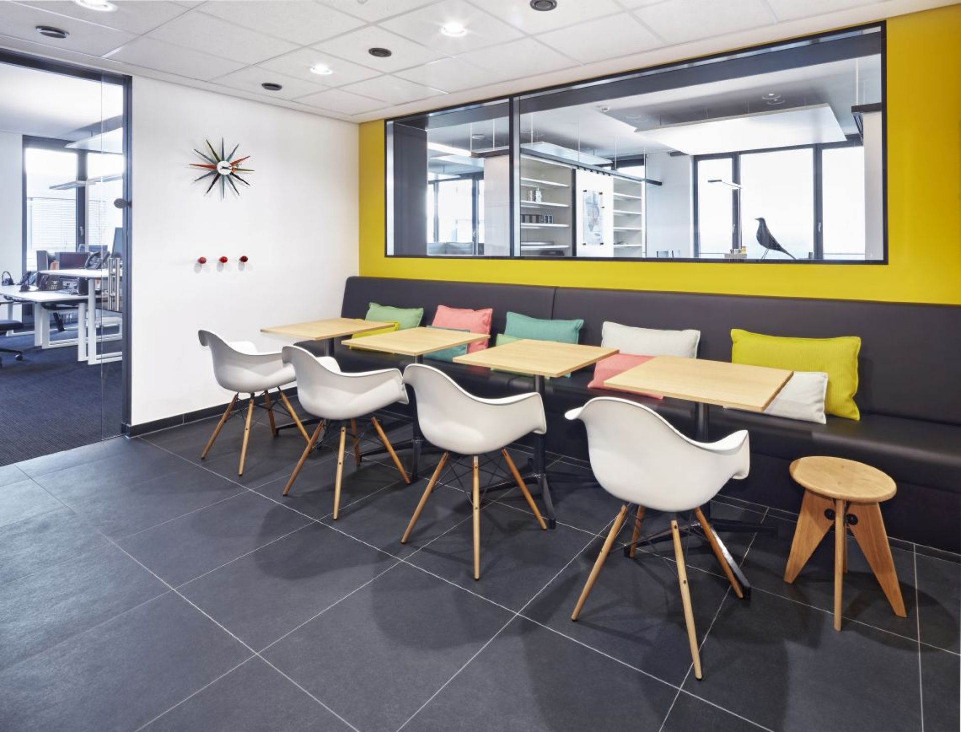 Innenaufnahme: Rechteckiger Bistro Table Tisch von Vitra mit weißen Stühlen und Sitzbank.