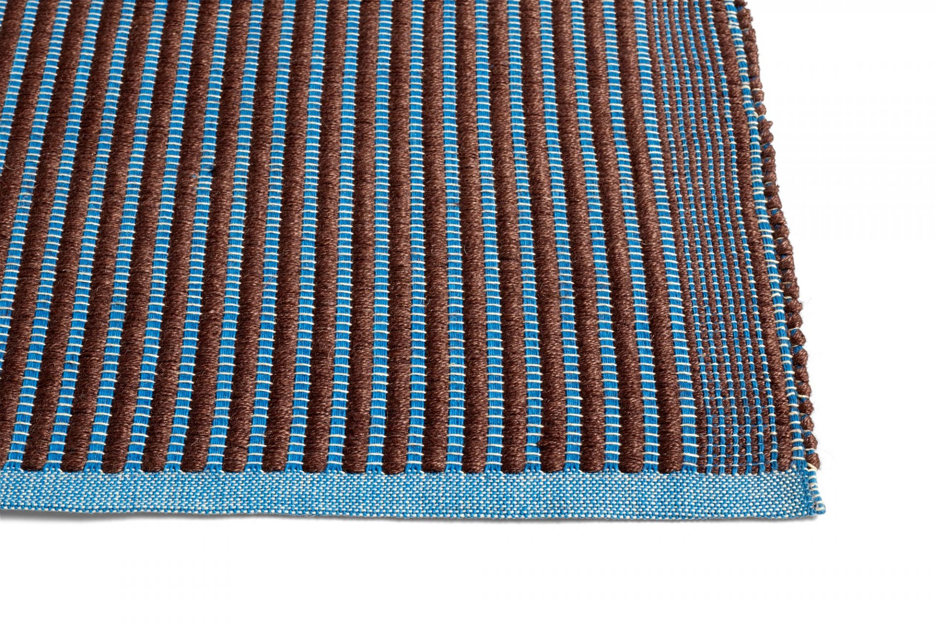 Detailaufnahme des Hay Tapis Teppichs mit braunen und blauen Streifen, moderner Teppich für Wohnzimmer und Schlafzimmer.