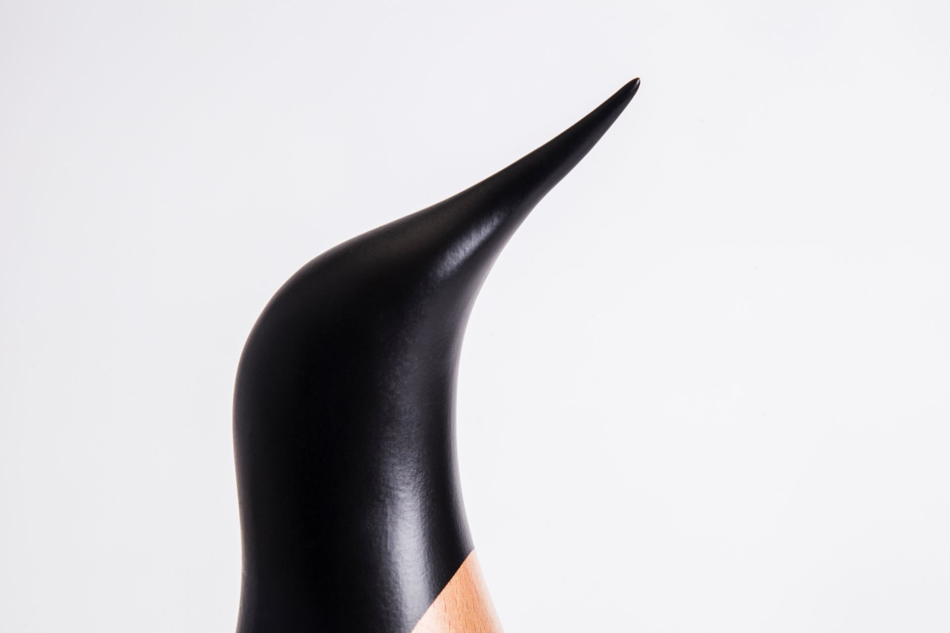 Detailaufnahme: Architectmade Pinguin Holzfigur, handgefertigte Dekoration aus Holz, modernes Design.