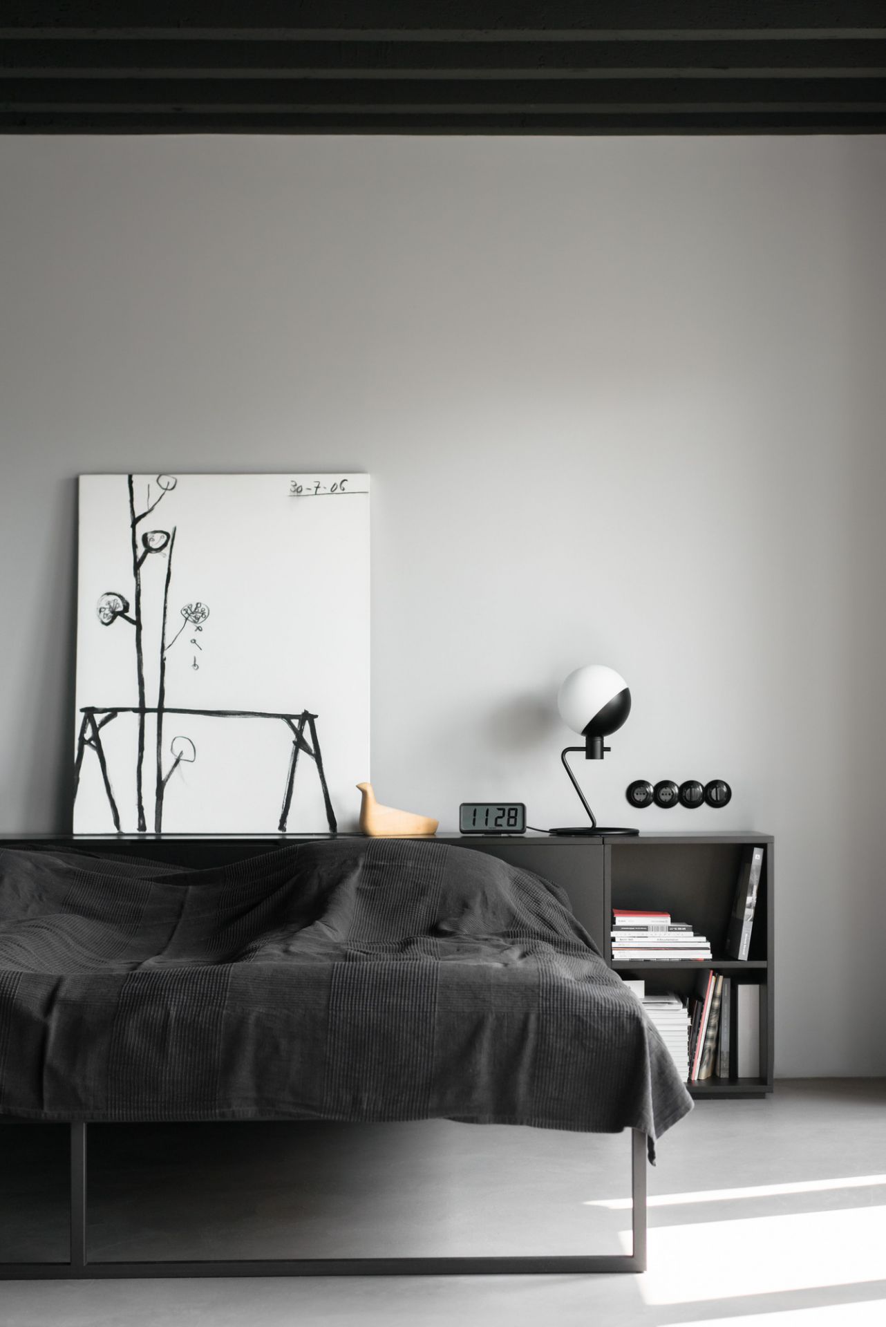 Schlafzimmer mit Baluna Tischleuchte von Grupa, Nachttisch, Bett und minimalistischer Dekoration.