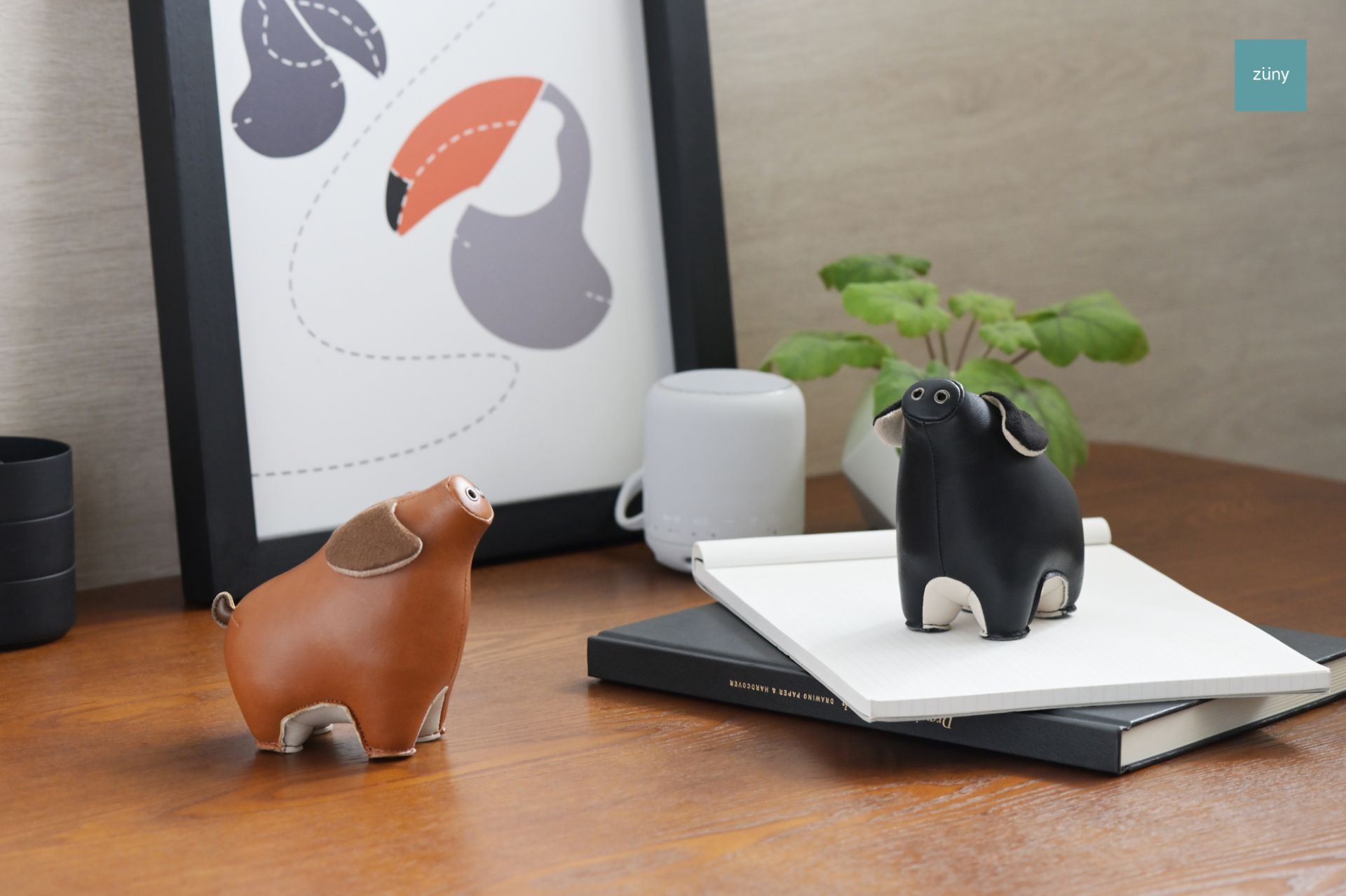 Zwei Züny Schwein Briefbeschwerer: Schwarz und Weizen, dekorative Buchstützen aus Kunstleder.