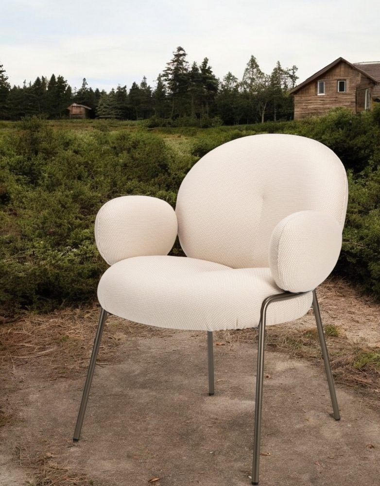 Nana Outdoor Armchair mit hohen Armlehnen von Freifrau Manufaktur, cremefarbener Stoffbezug und Metallgestell.
