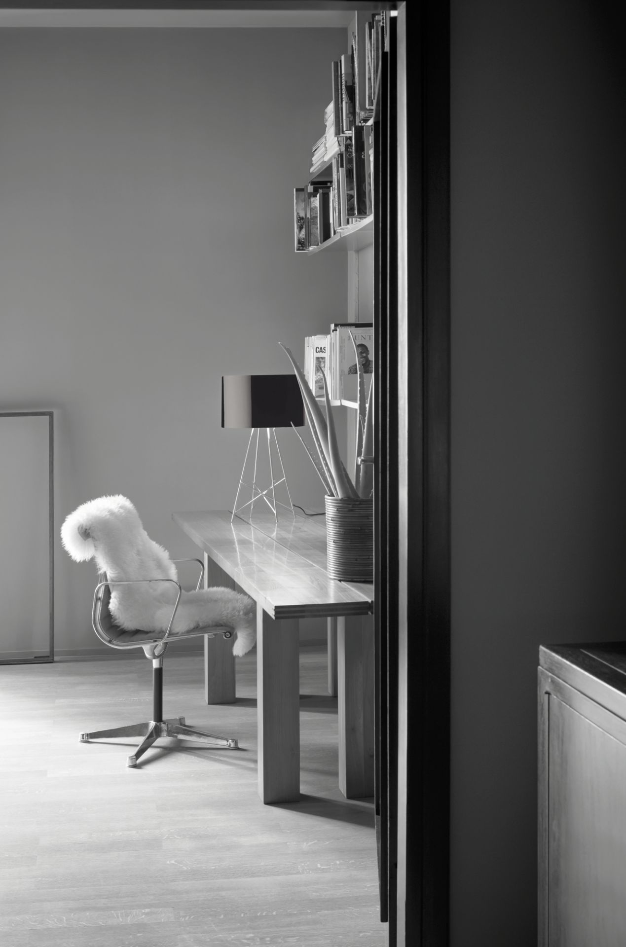 Ray T LED Tischleuchte von Flos auf Schreibtisch in modernem Arbeitszimmer, schwarz-weiß.