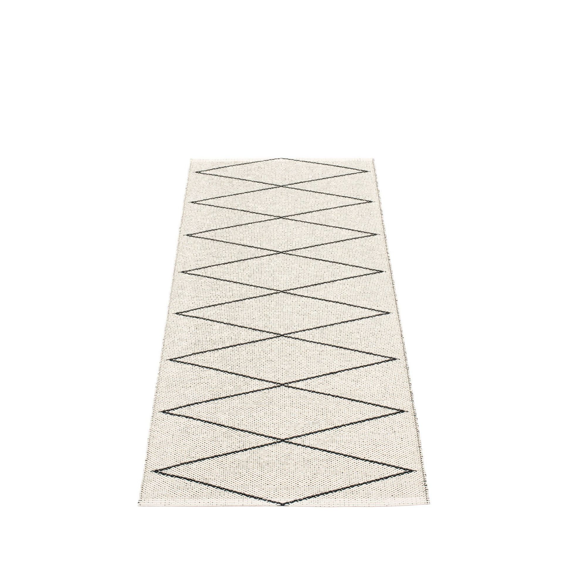 Max Kunststoffteppich von Pappelina, 70x160 cm, mit grafischem Rautenmuster in Schwarz auf hellem Grund.