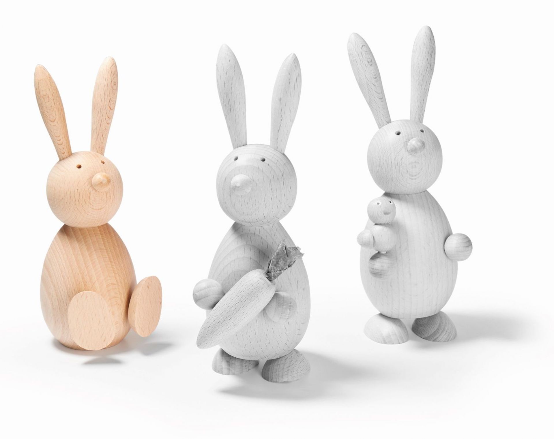 Drei Holzhasen, darunter ein Marti Hase, Osterdeko, handgefertigte Holzfiguren, skandinavisches Design, Osterhase, Dekoration.