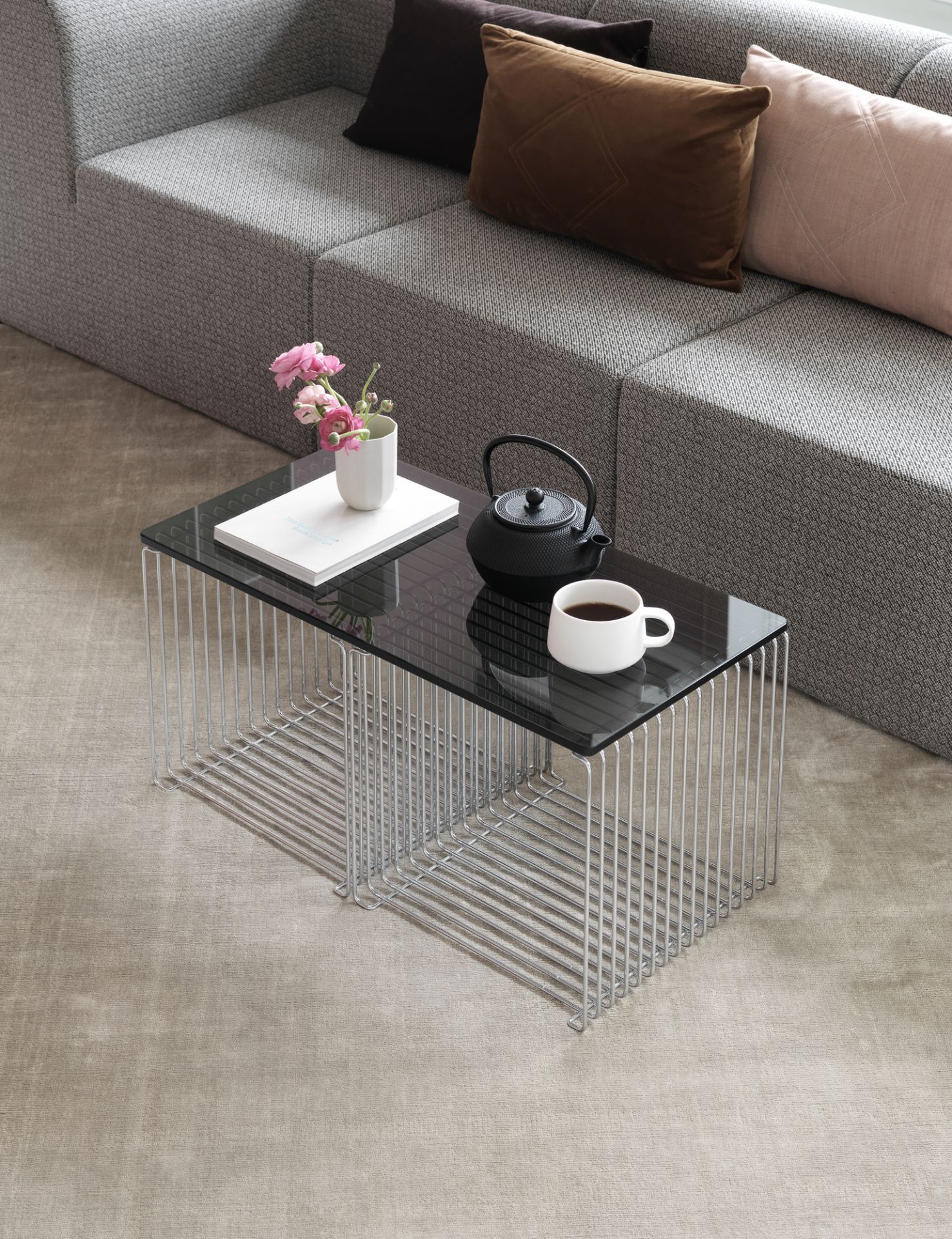 Panton Wire Cube Beistelltisch mit Glasplatte, Teekanne und Tasse auf einem modernen Couchtisch.