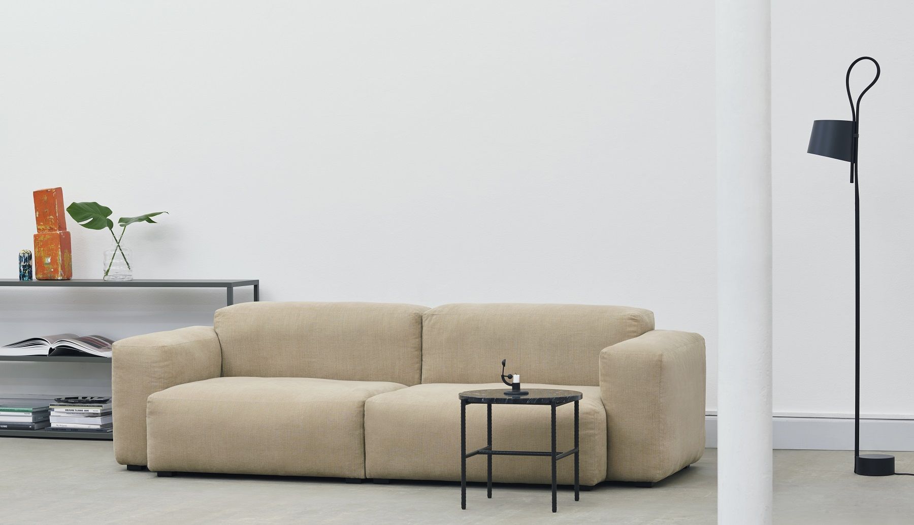 Beige Sofa mit schwarzem Hay Rebar Beistelltisch im minimalistischen Wohnzimmer. Moderner Couchtisch.