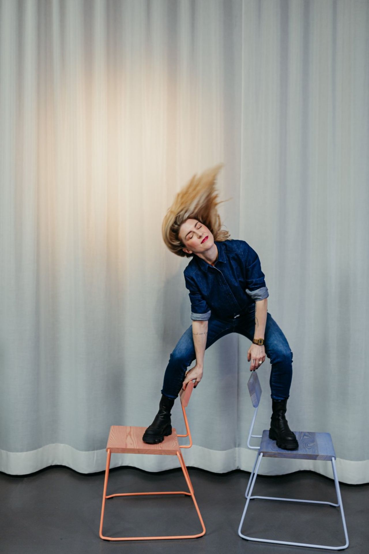 Frau balanciert auf zwei D:005 Stühlen von Fuchs & Habicht. Design Stuhl, Möbel.