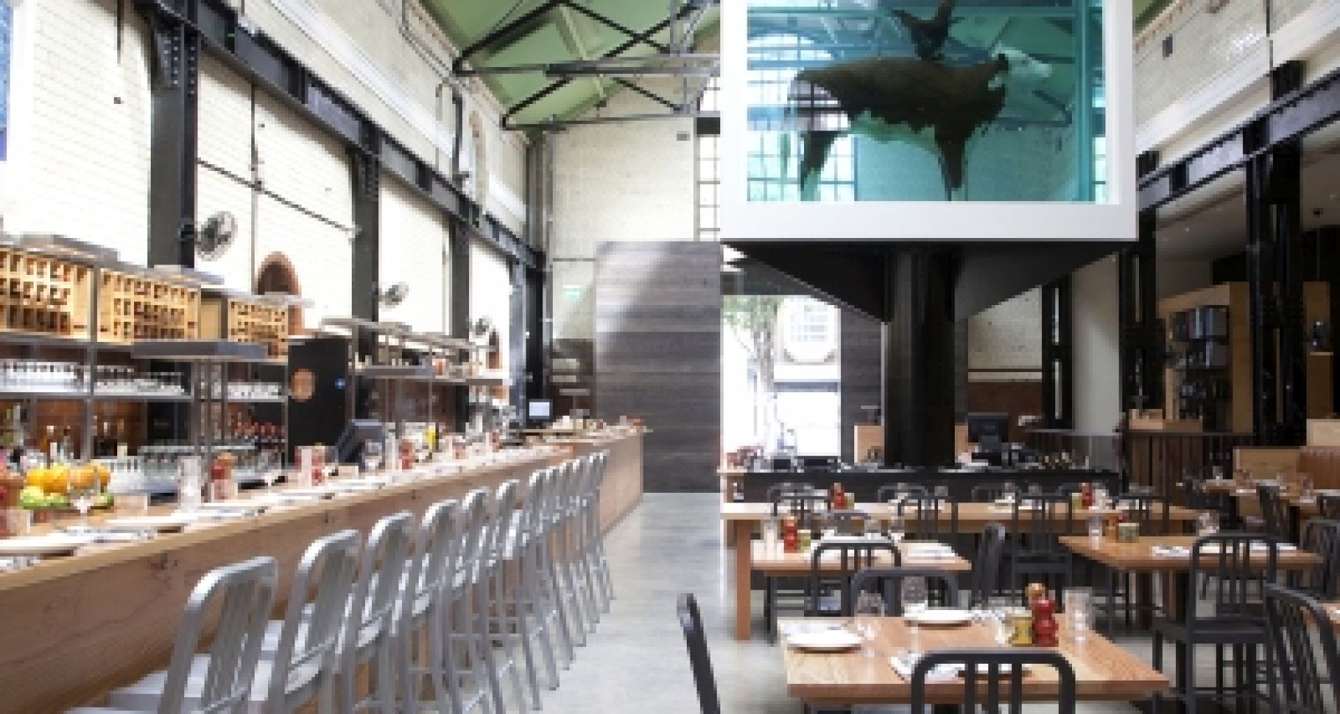 Innenaufnahme eines Restaurants mit Barhockern und Tischen.