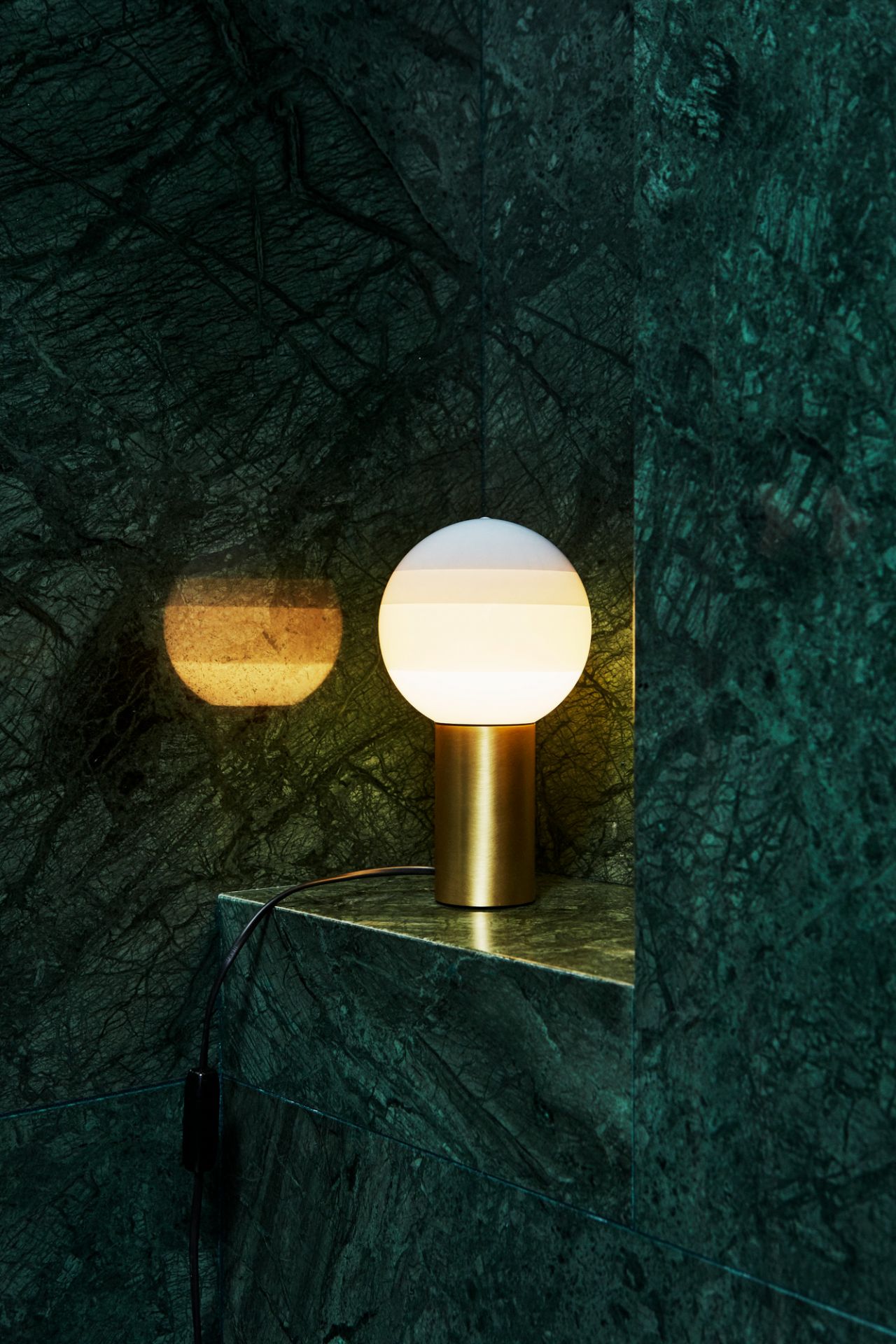 Nahaufnahme der Marset Dipping Light M LED Tischleuchte mit goldenem Sockel.