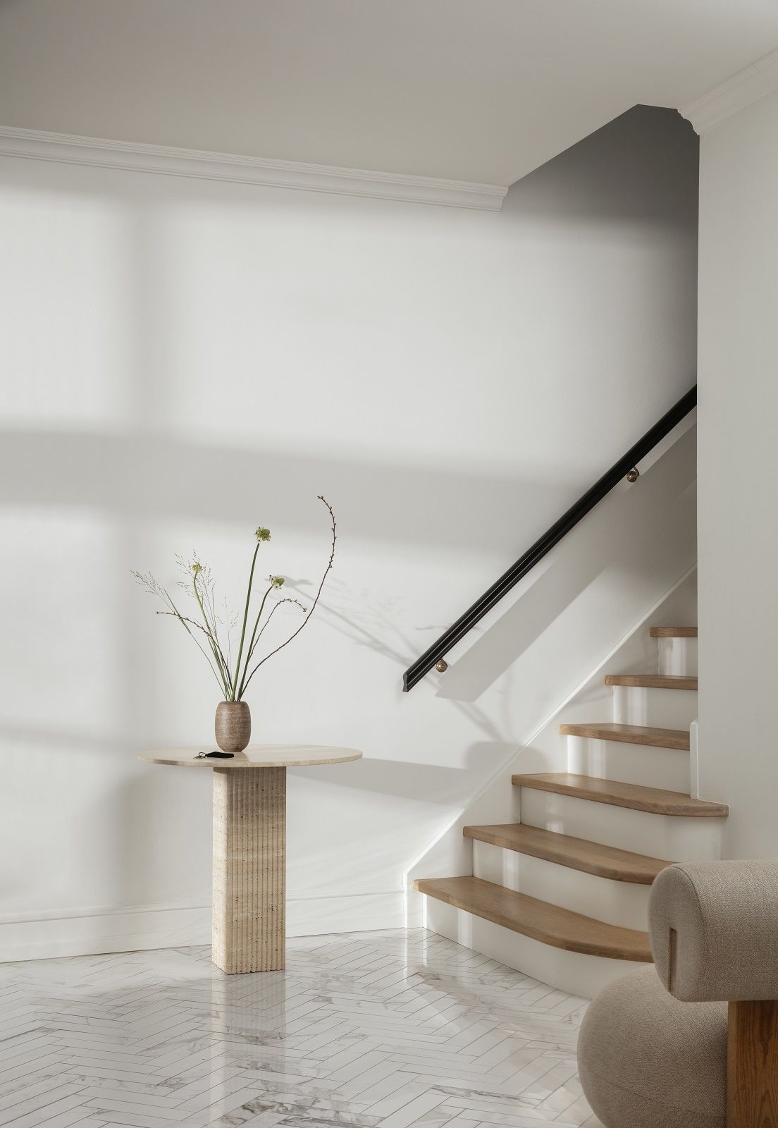 NORR11 Soho Dining Table Esstisch aus Travertin, runde Tischplatte mit Vase und Pflanzen.