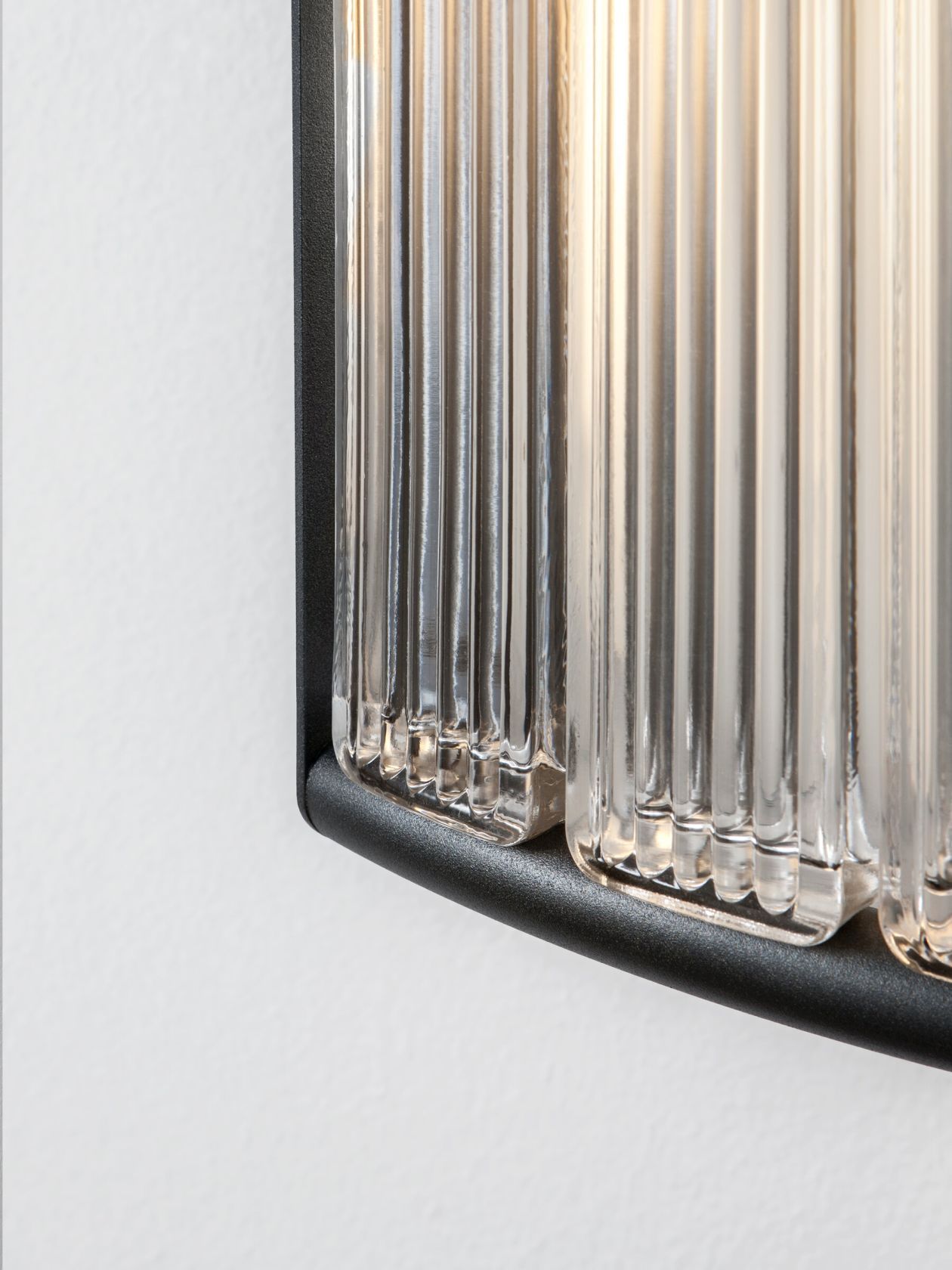 Detailaufnahme der Estadio Wandleuchte von Santa & Cole mit geriffeltem Glas und schwarzem Rahmen.