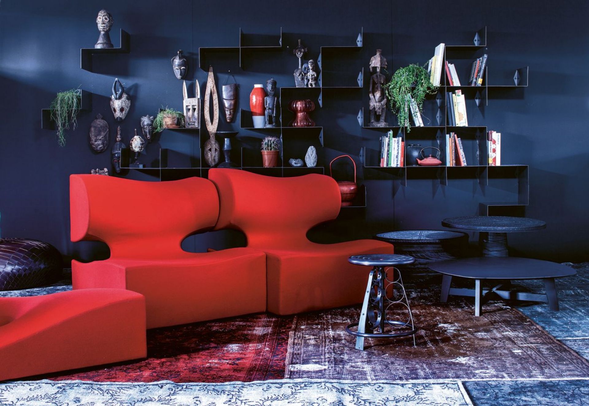 Wohnzimmer mit rotem Moroso Sofa, Z-Shelf Wandregal mit Deko und Teppich für modernes Wohnen.