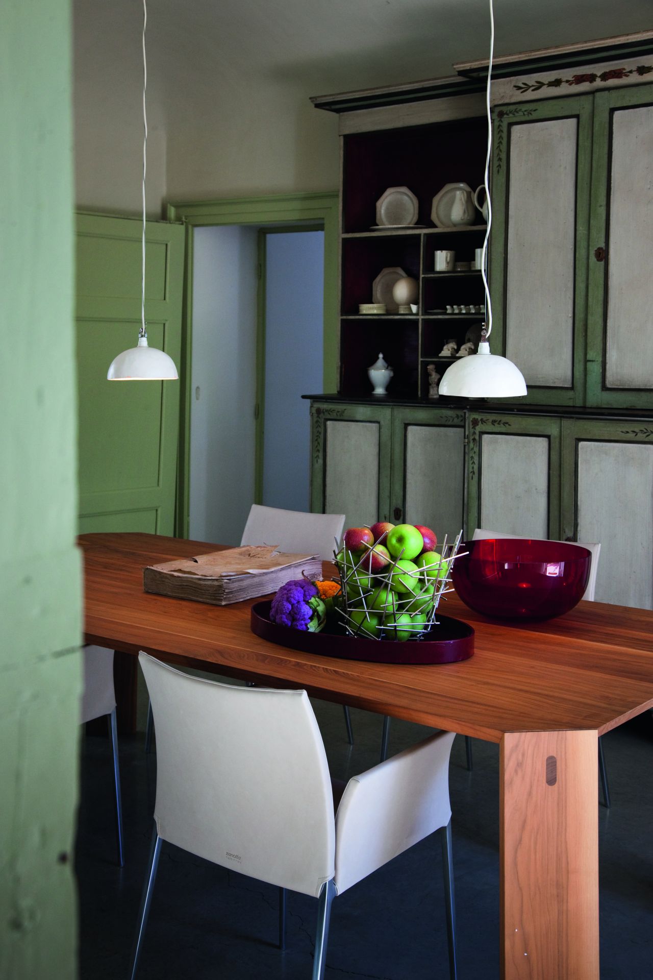 Esszimmer mit Holztisch und weißen Lia Stühlen von Zanotta mit Armlehnen. Modernes Design.