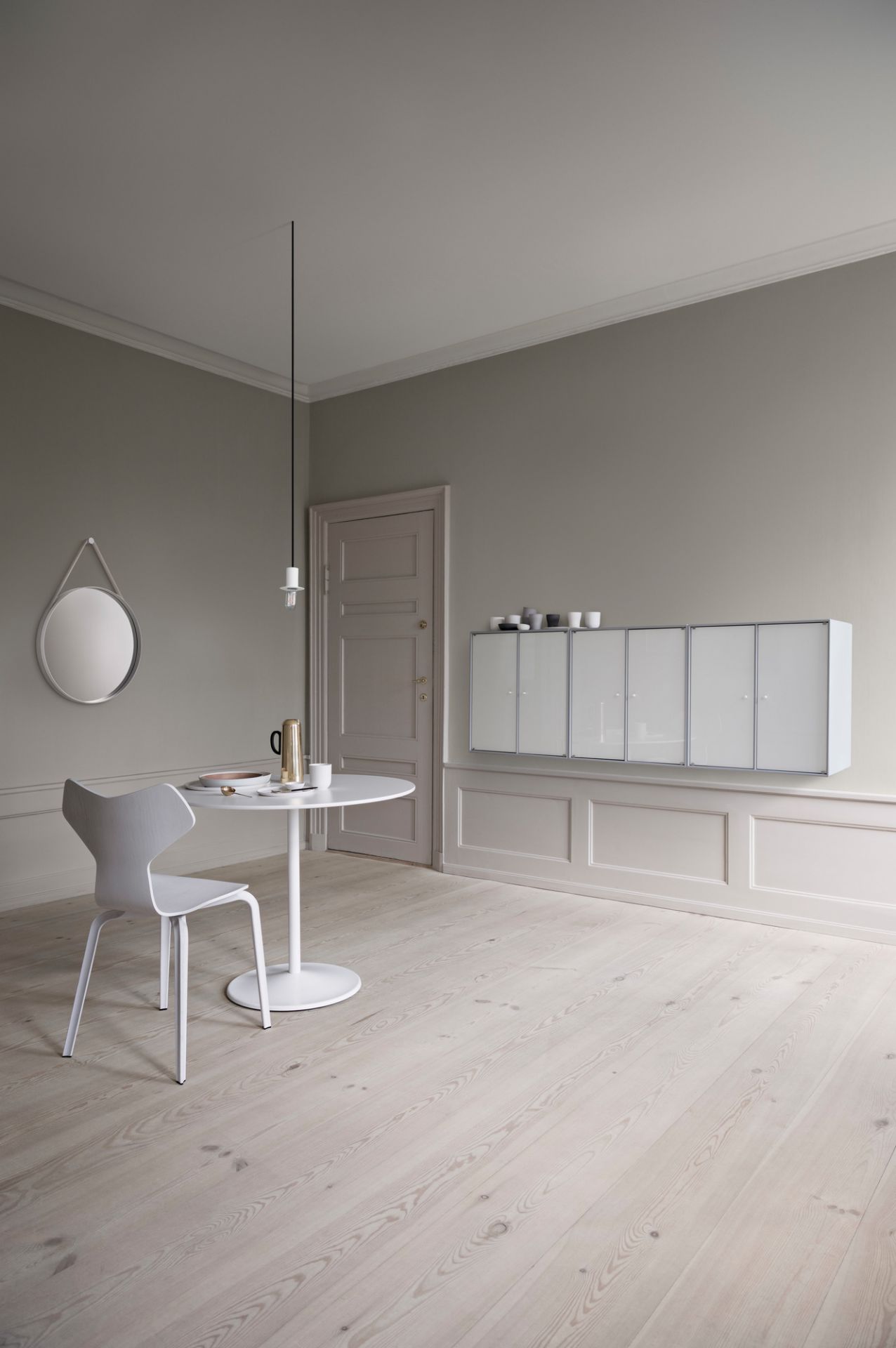 Heller Raum mit Panton Table Tisch, weißem Stuhl und Montana Wandregalen für modernes Wohnen.