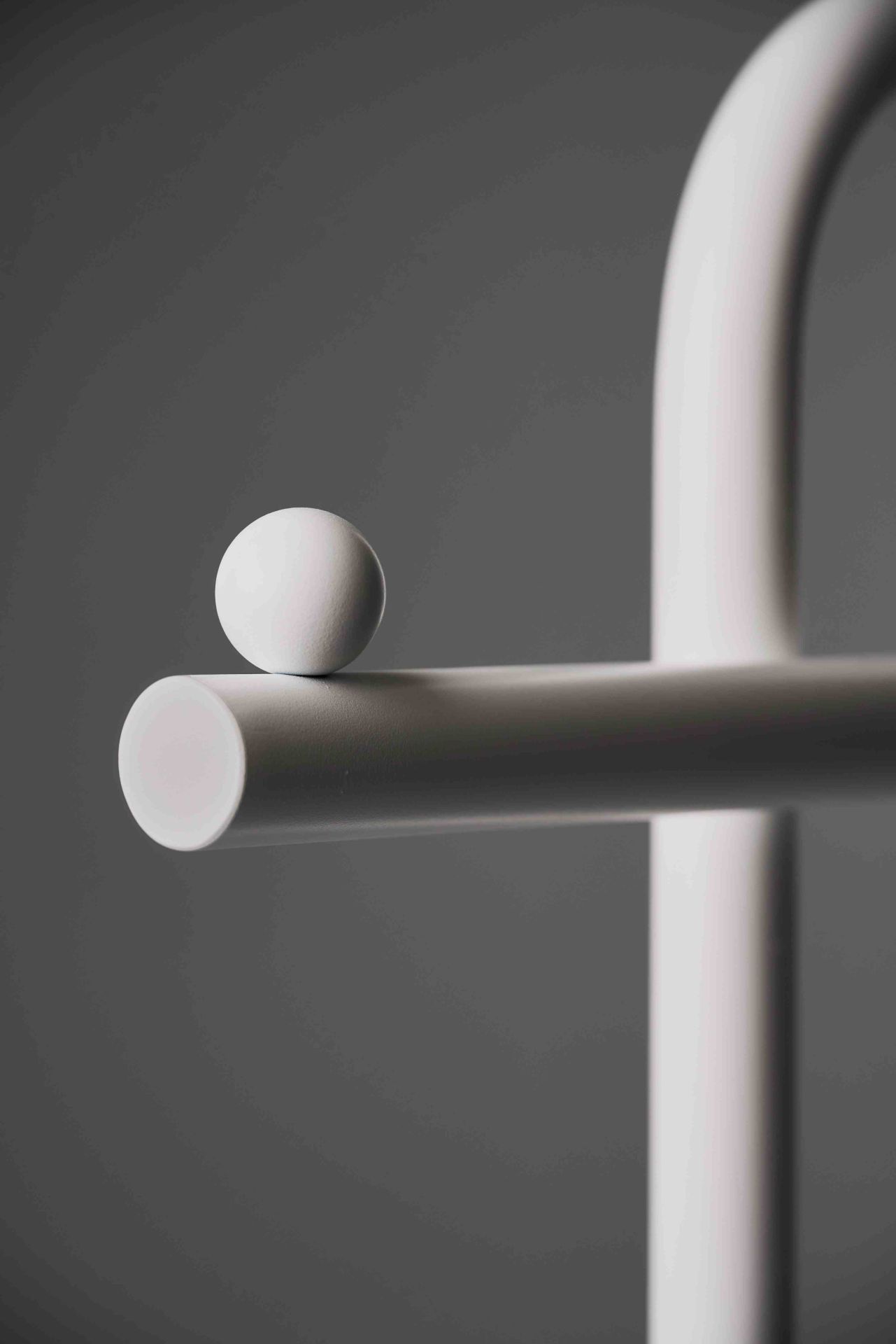 Detailaufnahme des Schönbuch Slinga Garderobenständers in Weiß mit einer Kugel. Modernes Design für Flur und Diele.