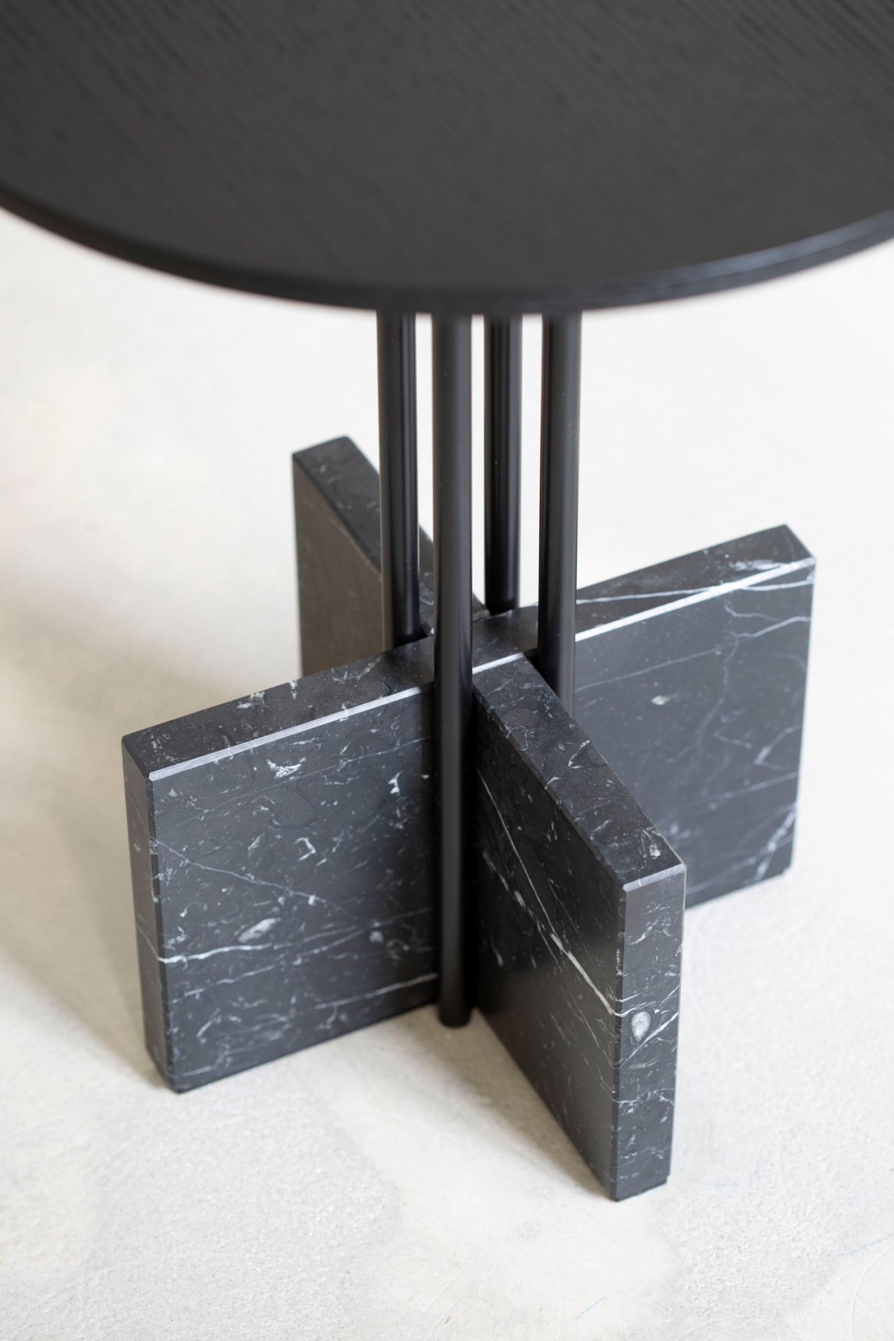 Detailaufnahme: Gravity Table Beistelltisch mit schwarzer Tischplatte und Marmorfuß. Design Beistelltisch für Wohnzimmer.