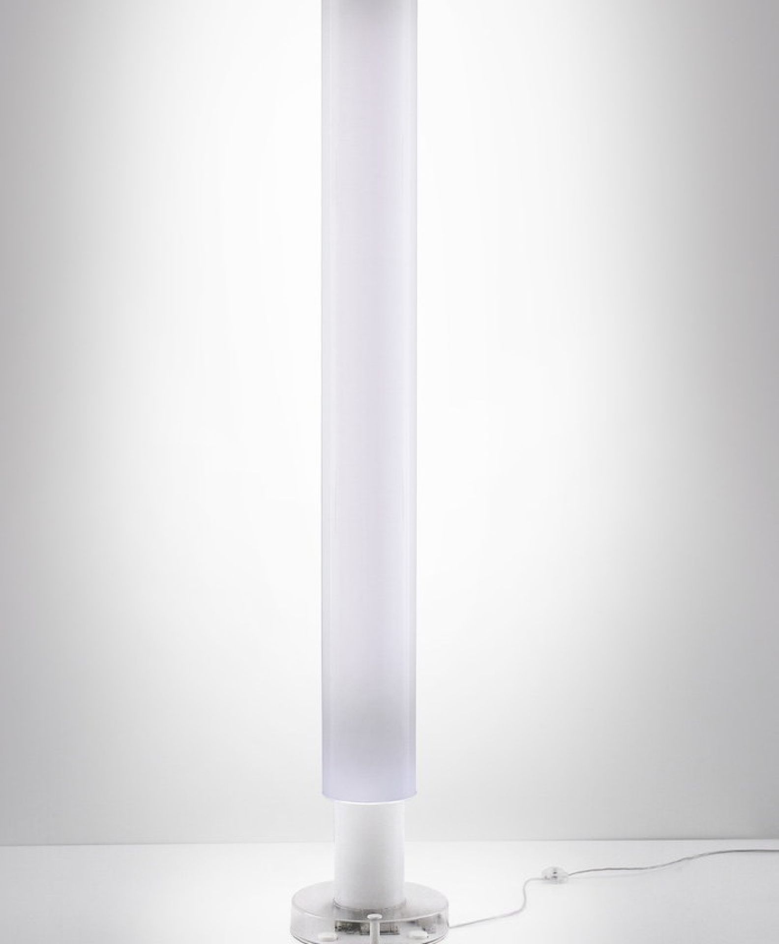 Metacolor Stehleuchte von Artemide: Moderne, zylindrische Stehlampe mit weißem Diffusor und transparentem Fuß.