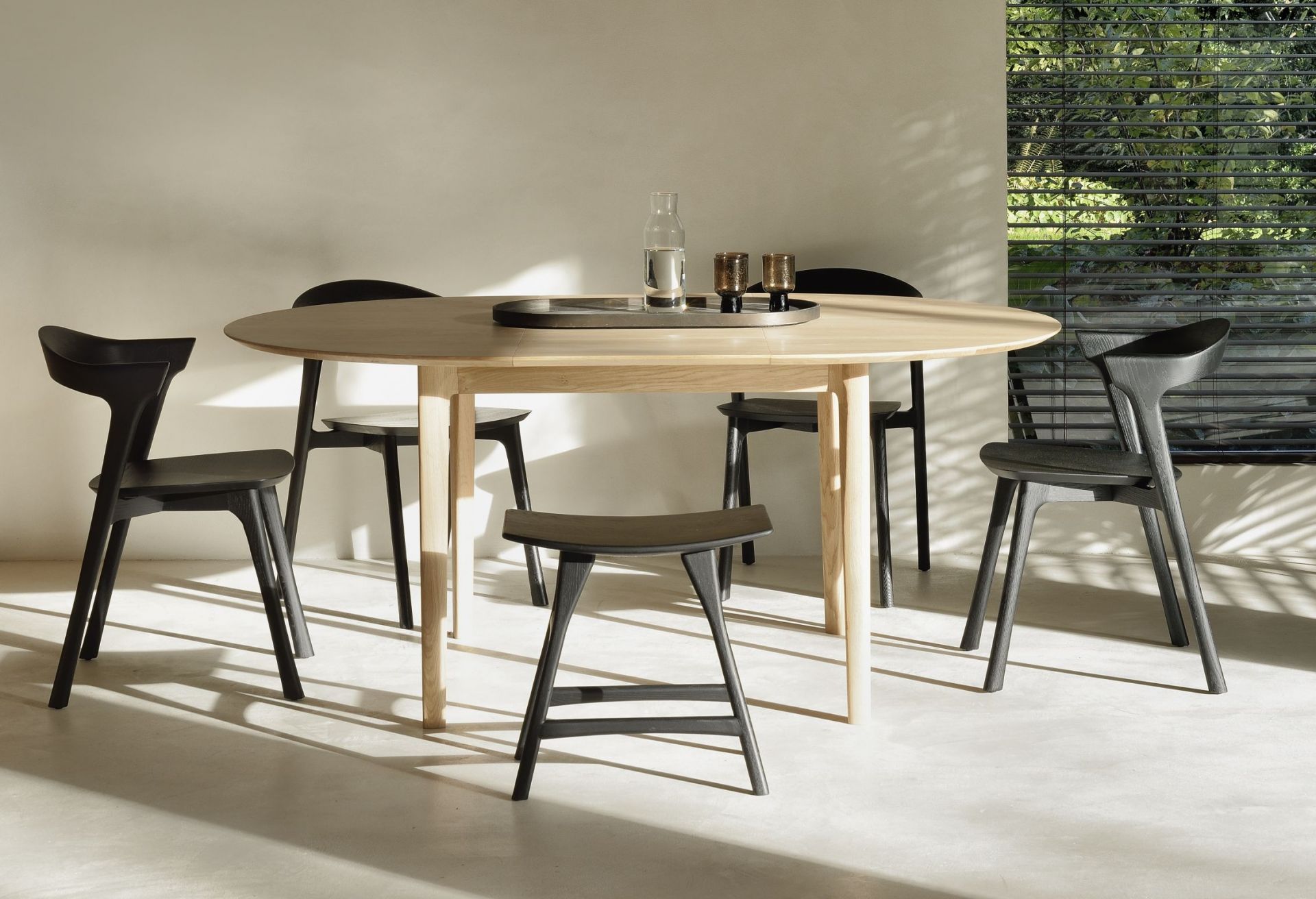 Esstisch mit Ethnicraft Osso Stühlen aus schwarzem Eichenholz und passendem Hocker im Esszimmer.