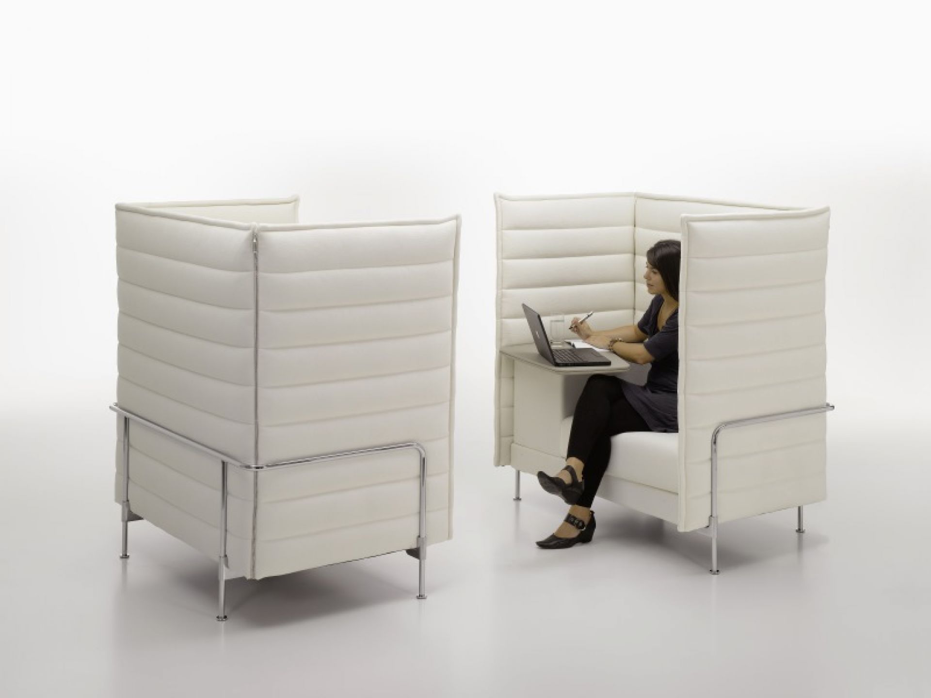 Alcove Highback Sessel von Vitra: Frau arbeitet am Laptop in weißem Bürosessel.