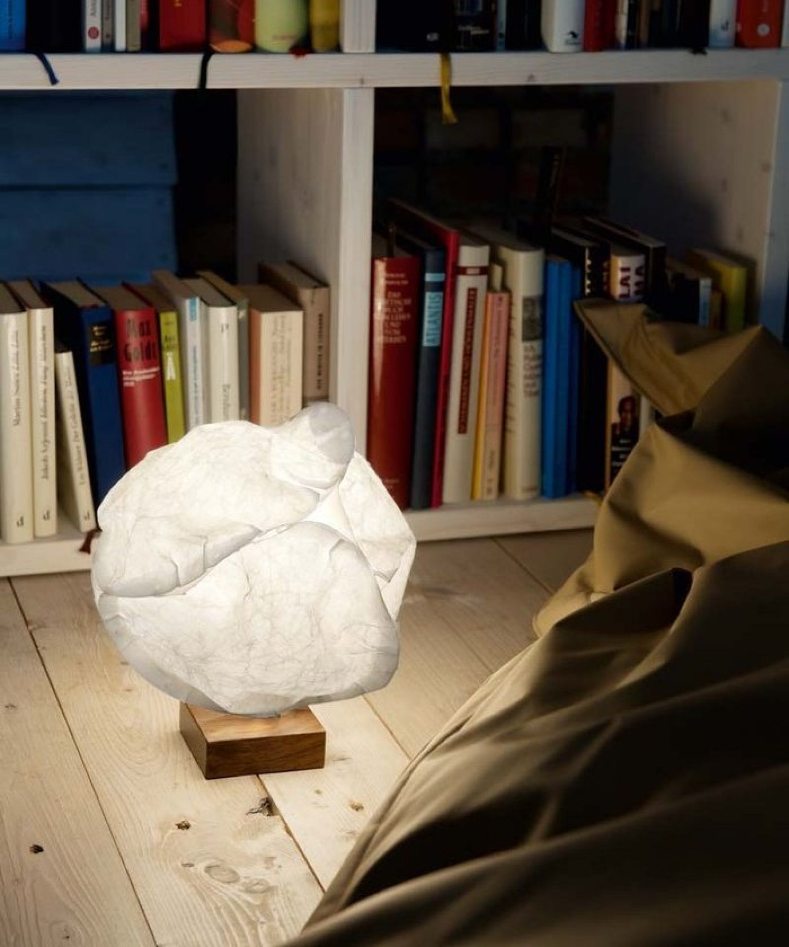 Babycloud Tischleuchte von Belux: Wolkenförmige Lampe auf Holzsockel vor Bücherregal. Dekorative Beleuchtung.