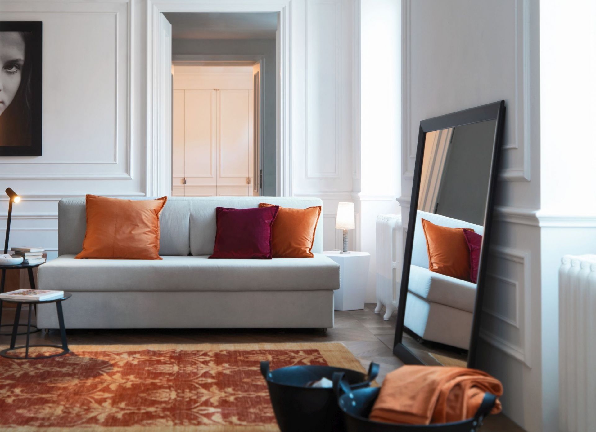 Wohnzimmer-Szene mit Albino Torcia Beistelltisch in Schwarz, neben Sofa mit Kissen und Dekoration.