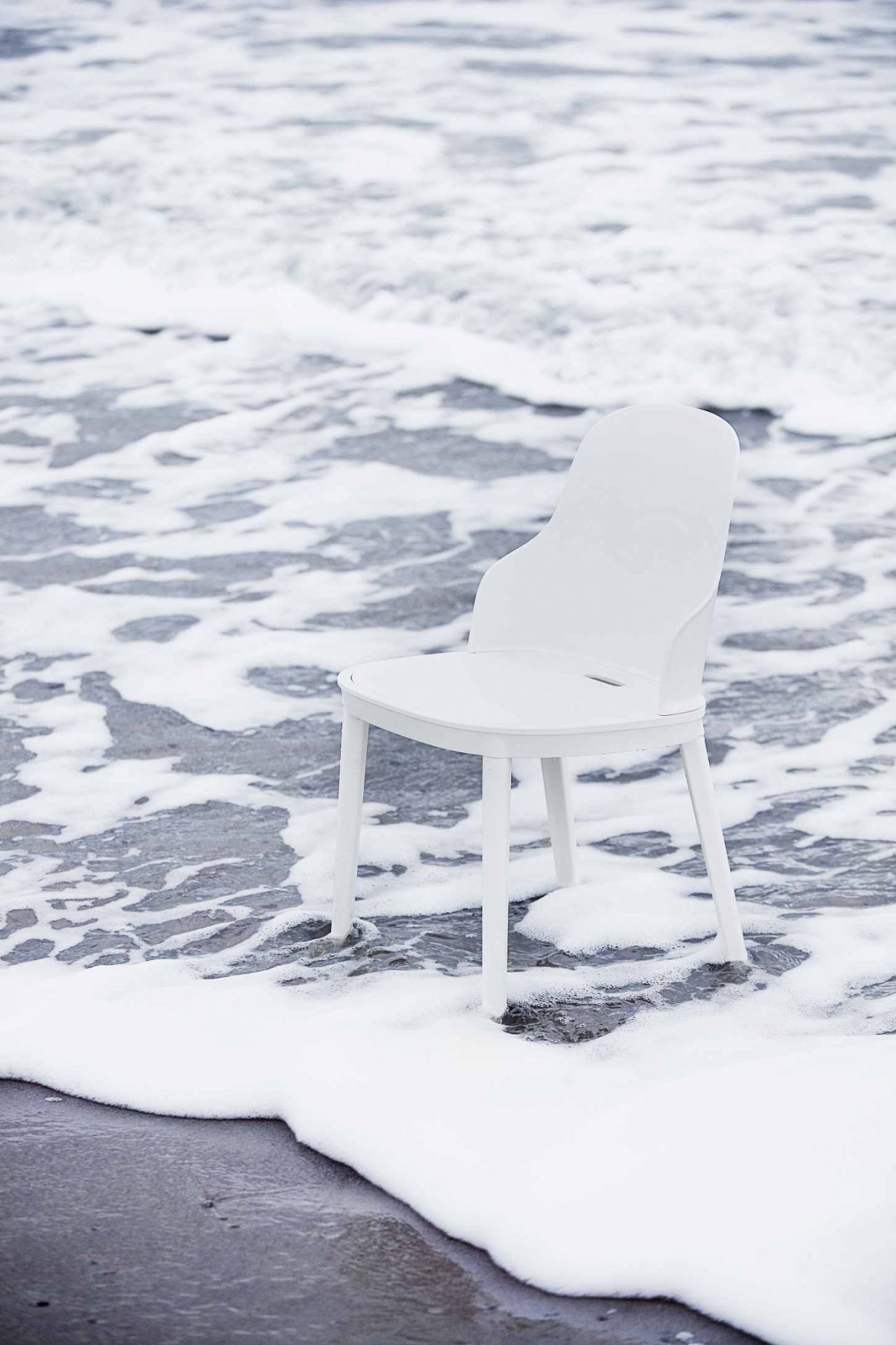 Weißer Allez Chair Stuhl von Normann Copenhagen am Strand im Meerwasser. Designstuhl.