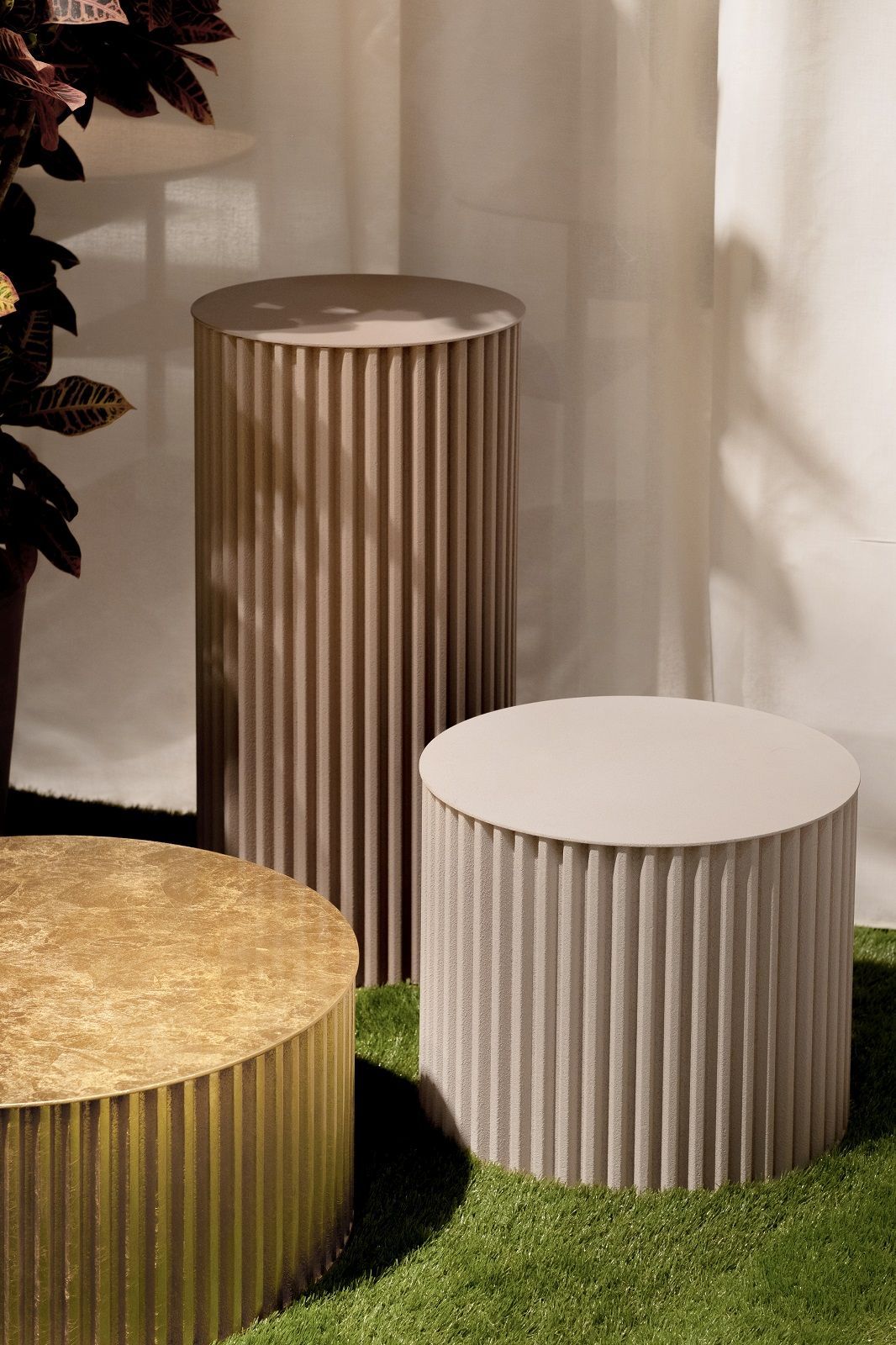 Herclino Couchtisch: Drei runde Beistelltische in Gold und Beige mit geriffelter Oberfläche.