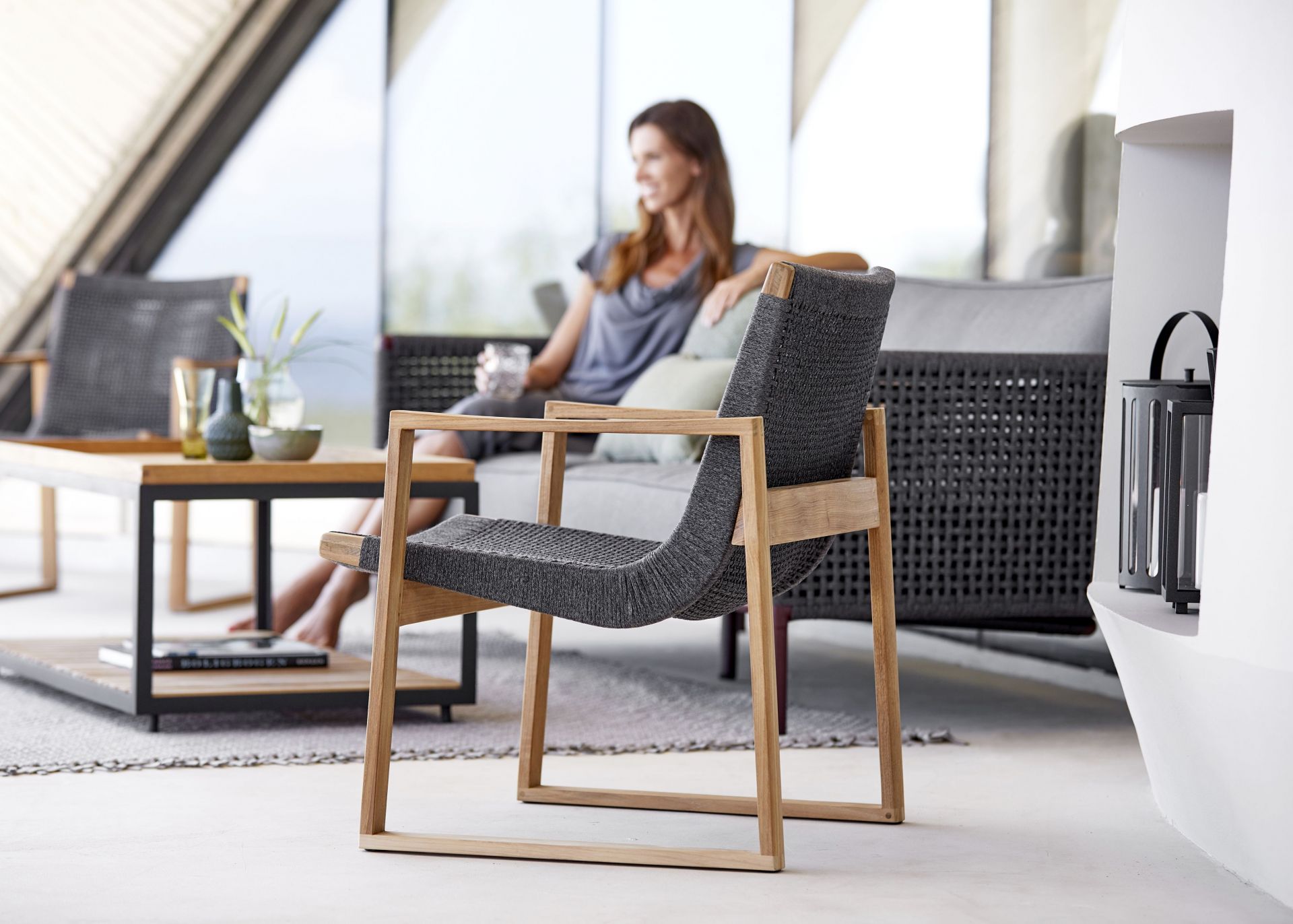 Endless Loungesessel von Cane-Line mit grauem Geflecht und hellem Holzgestell für den Garten.