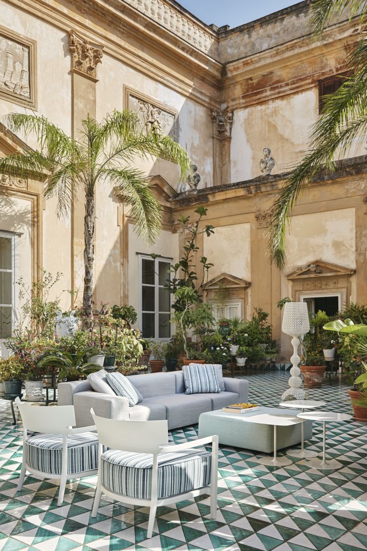 Plastics Outdoor Kissen Kartell: Graues Outdoor Sofa und Sessel mit blau-weiß gestreiften Kissen.