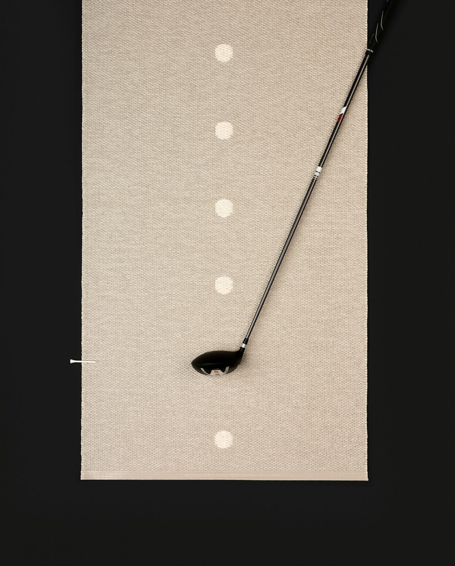 Beiger Pappelina Kunststoffteppich mit Golfschläger und Tee, geeignet für drinnen und draußen.