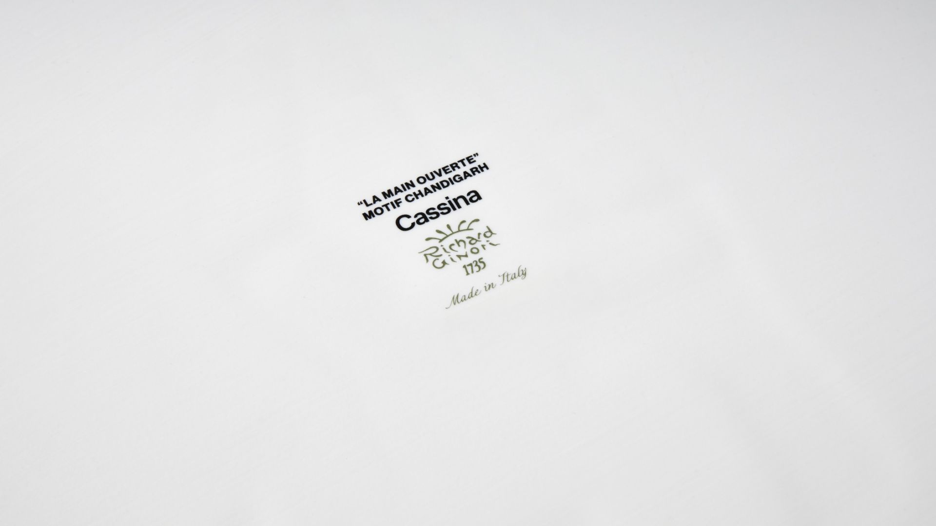 Detailansicht des Cassina Chandigarh Tabletts mit "La Main Ouverte" Motiv und Richard Ginori Logo.