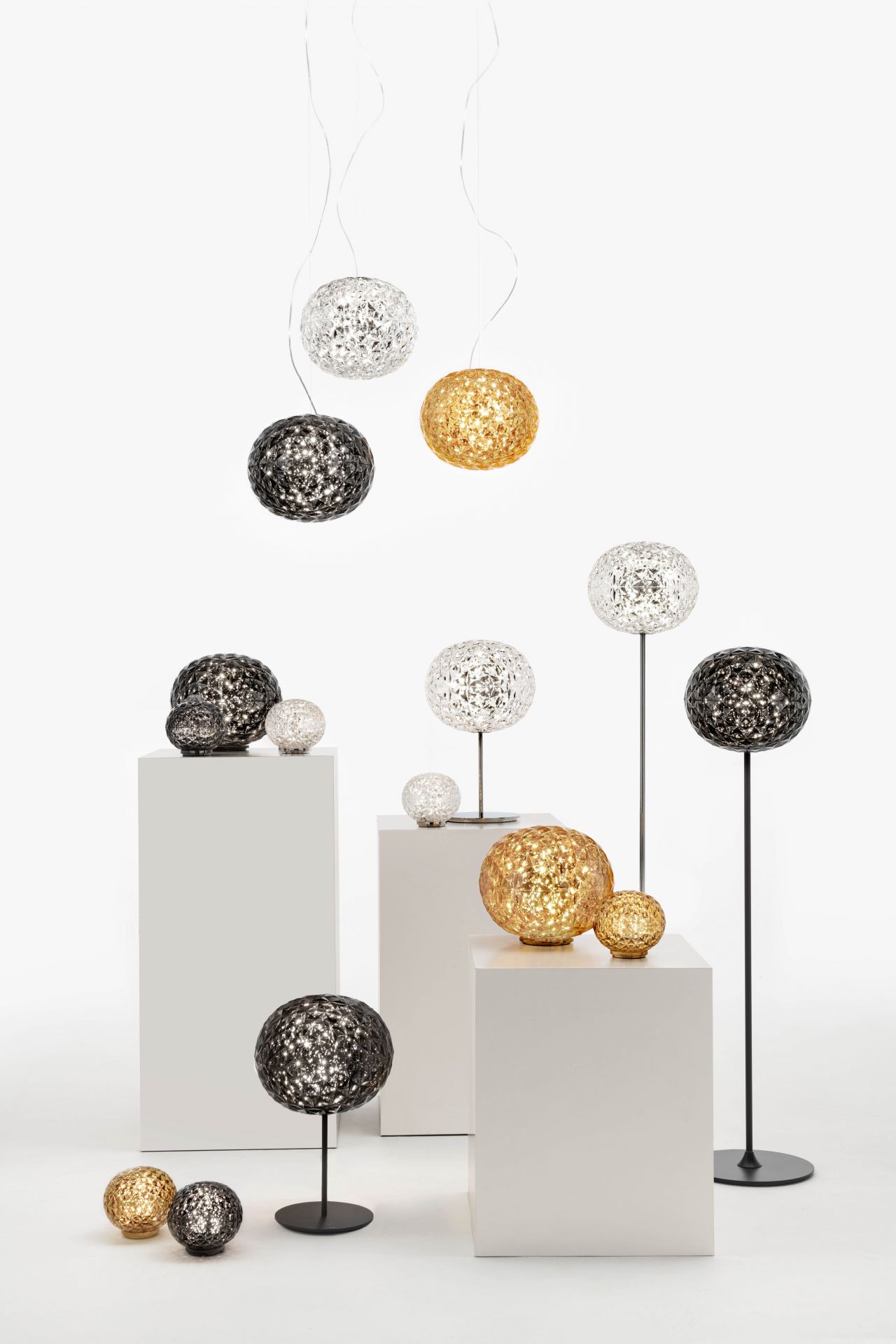 Verschiedene Kartell Mini Planet LED Lampen: Tischleuchten, Stehleuchten und Pendelleuchten in Gold, Silber und Schwarz.