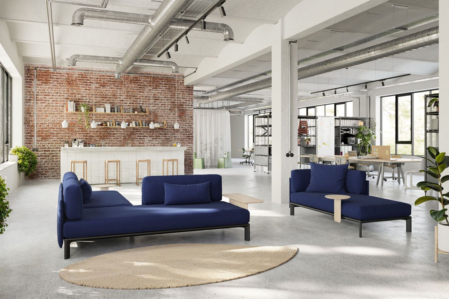Blauer Vitra Anagram Plattformverbinder im modernen Büro-Loft. Modulares Sofa-System für flexible Raumlösungen.