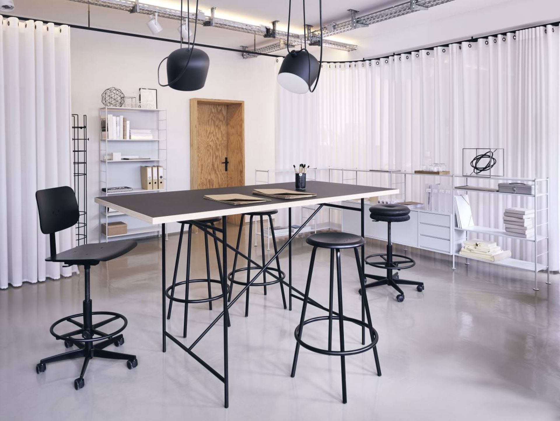 Milla Stehtisch von Richard Lampert, 180x90 cm, mit schwarzen Barhockern in einem modernen Büro.