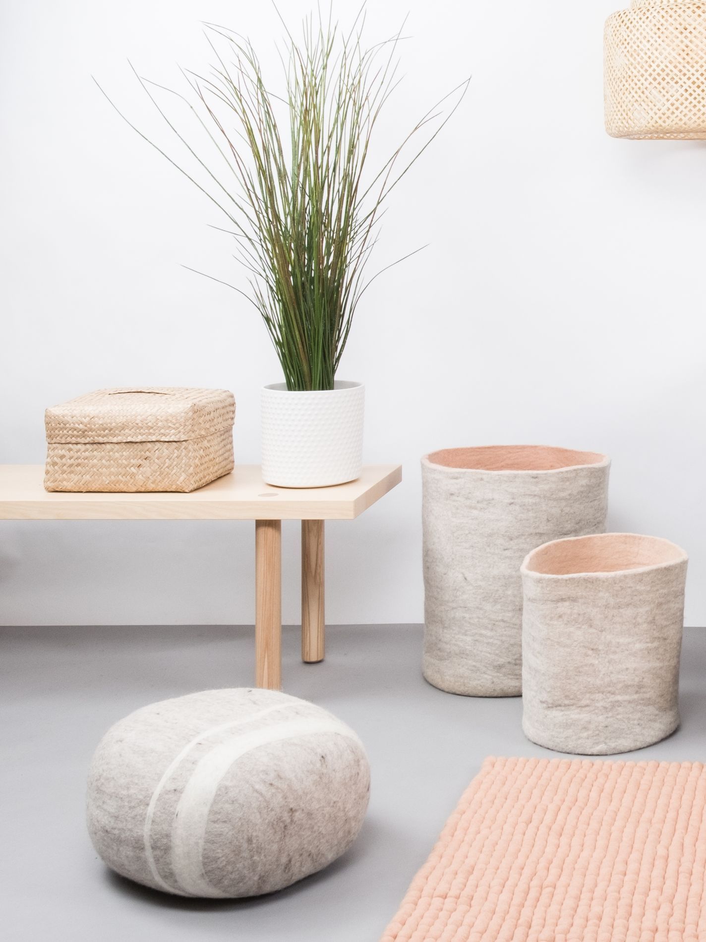 Filzkorb L Béla myfelt, zwei graue Filzkörbe mit rosa Innenseite auf grauem Boden.