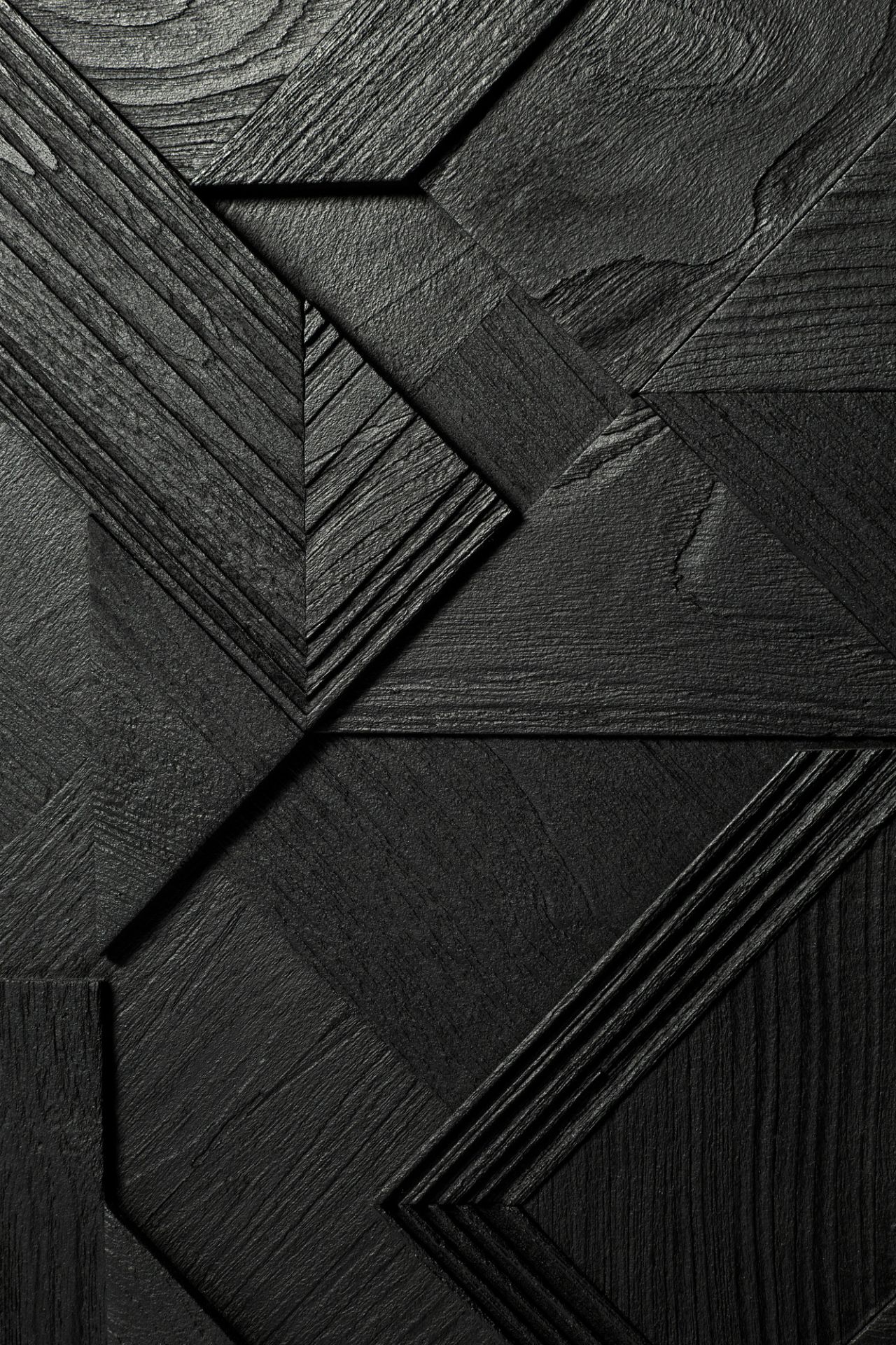 Detailaufnahme der schwarzen Teakholz-Oberfläche der Graphic Anrichte von Ethnicraft mit geometrischen Mustern.