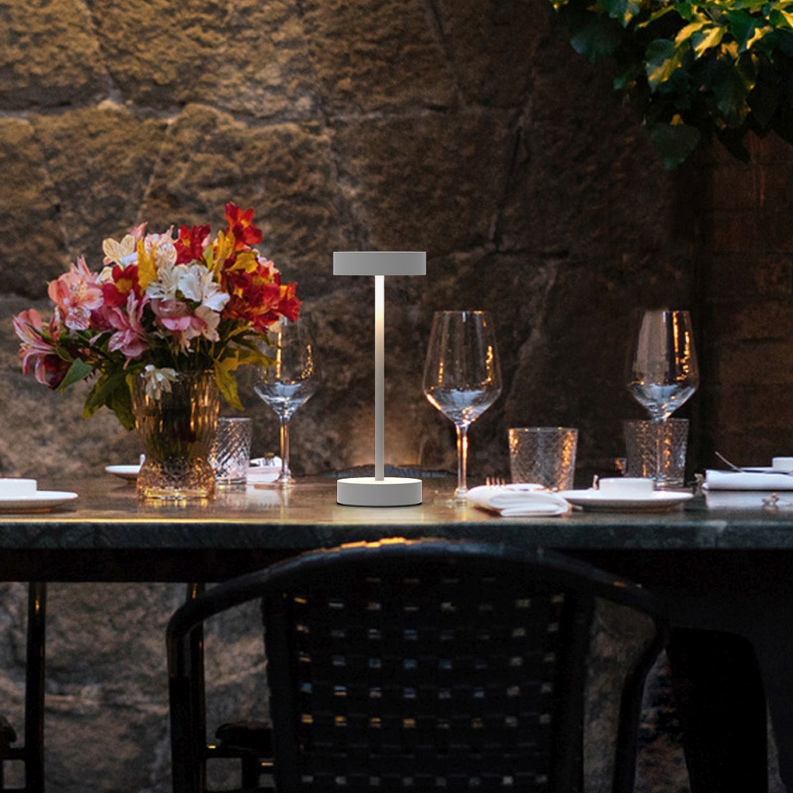 Weiße Arnold S Akkuleuchte von Moree auf einem gedeckten Tisch im Freien.