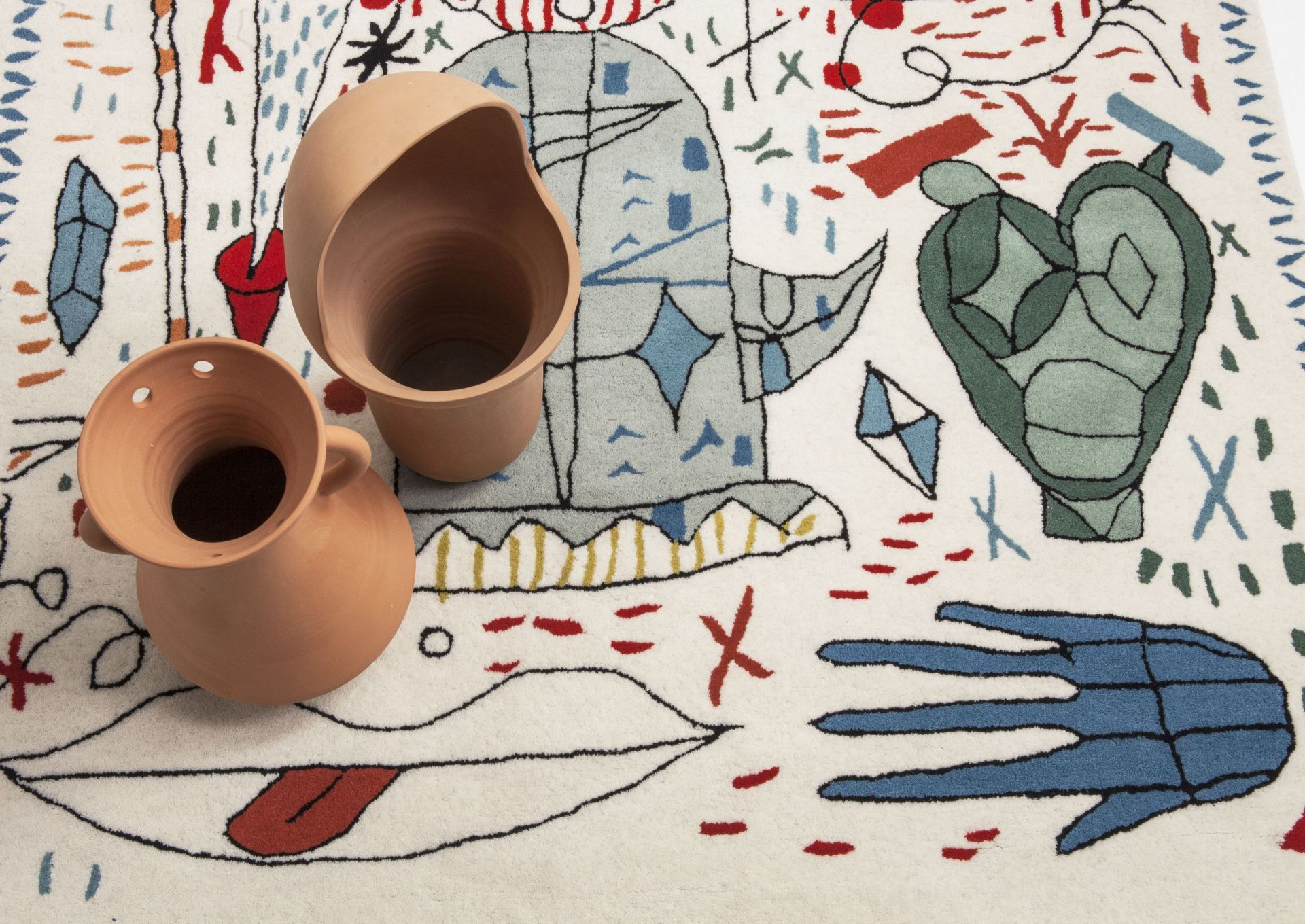 Hayon x Nani Teppich mit abstrakten Motiven und zwei Terrakotta-Vasen im Vordergrund.