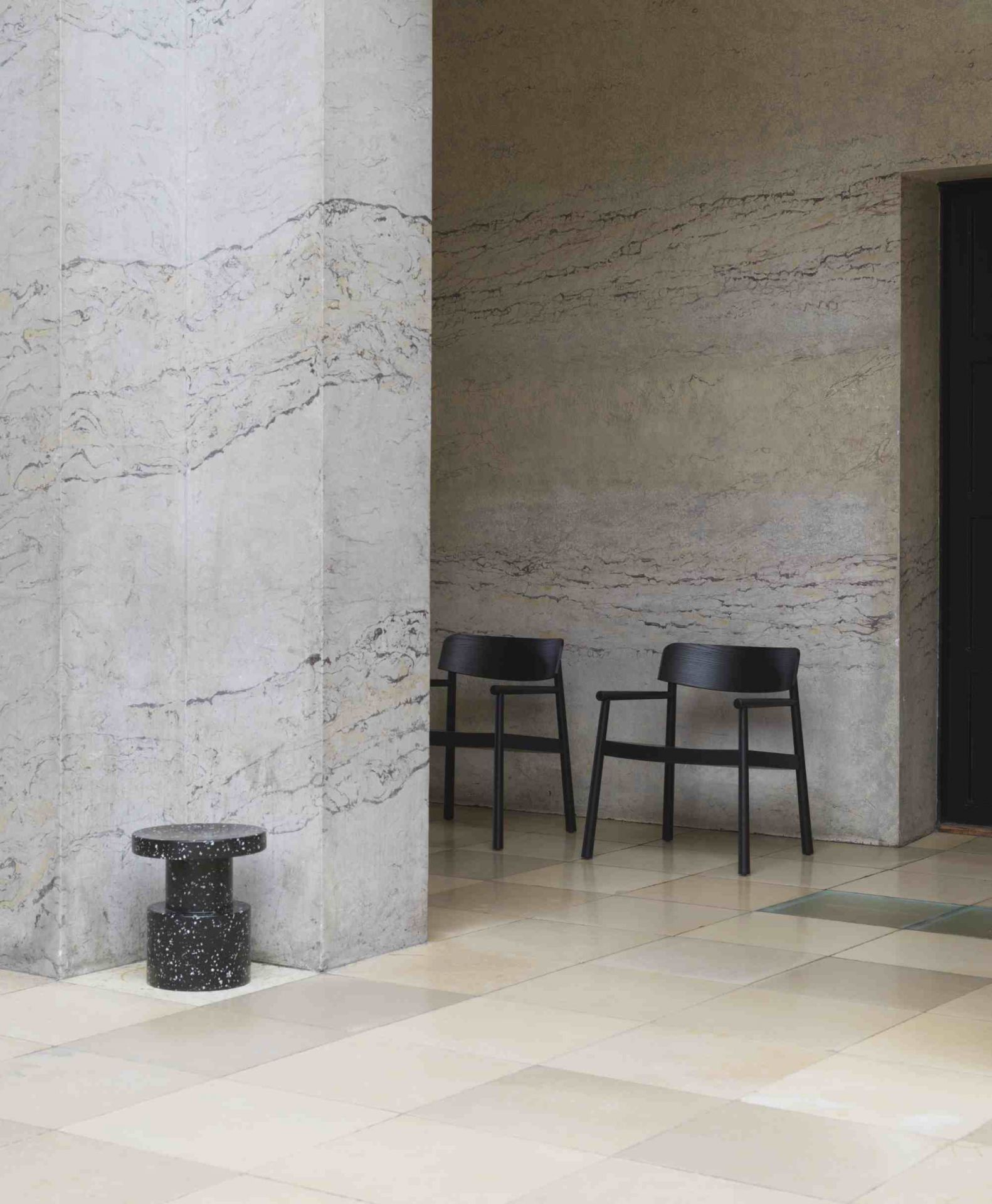 Schwarzer Bit Stool Hocker von Normann Copenhagen mit gesprenkeltem Muster im minimalistischen Raum.