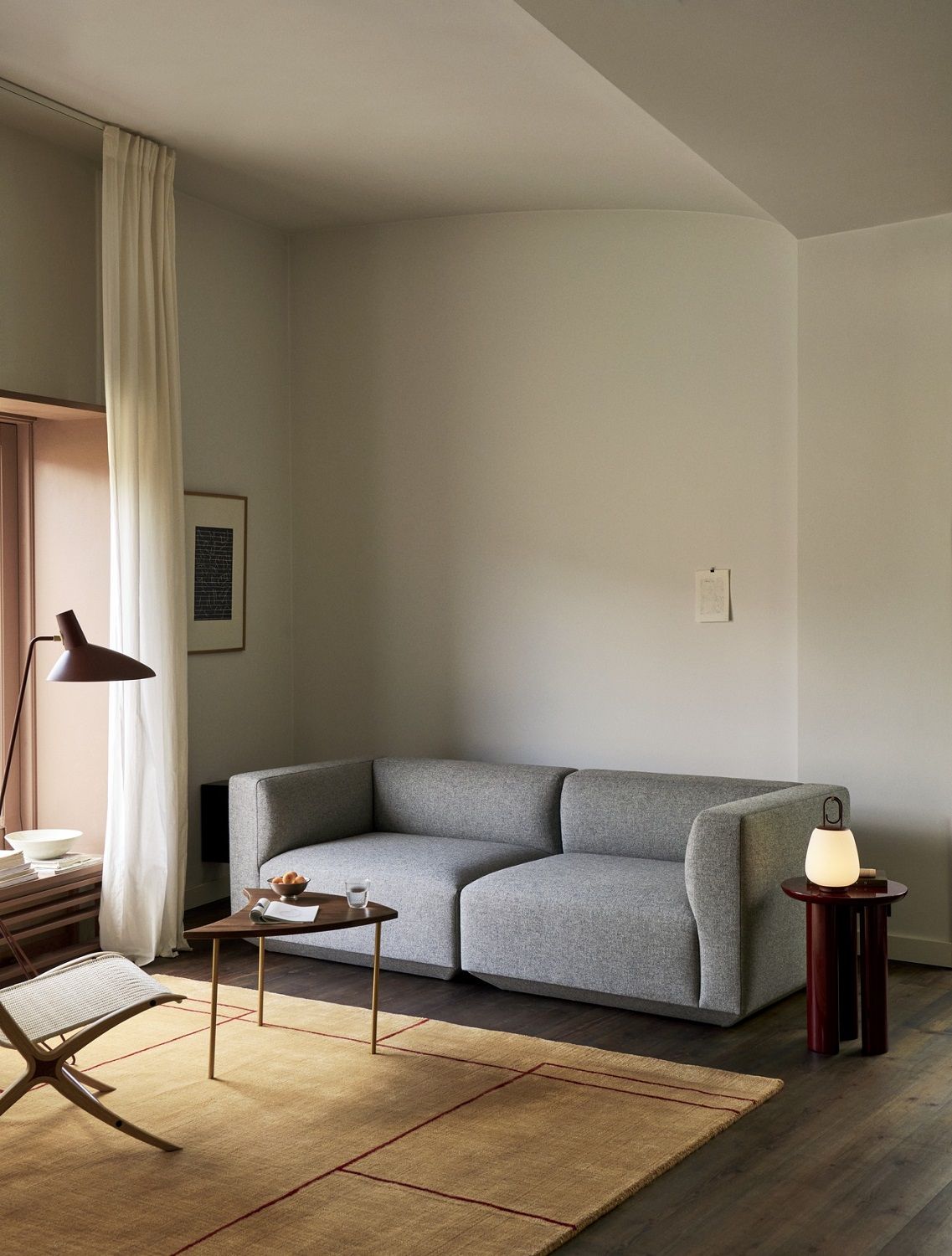 Graues Develius Sofa von AndTradition, Konfiguration A und B, in modernem Wohnzimmer mit Teppich und Beistelltischen.