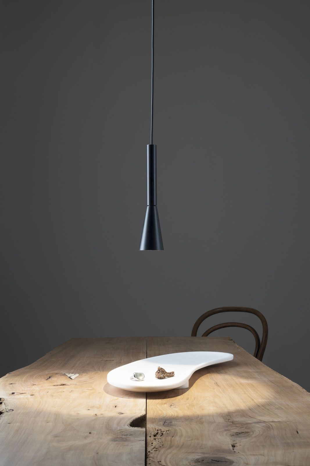 Colibrì Pendelleuchte von Martinelli Luce in Schwarz über einem Holztisch mit Dekoration.