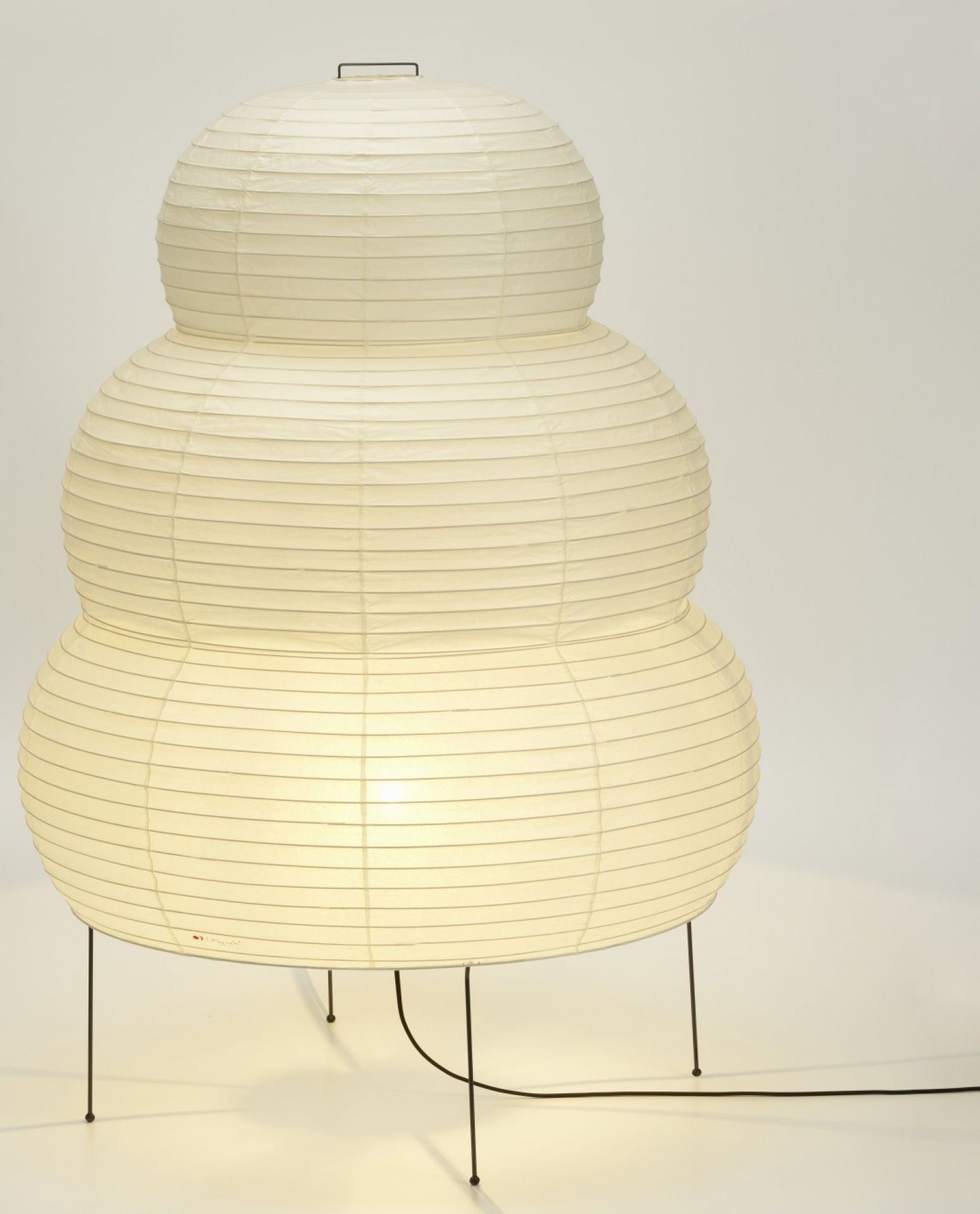 Akari Stehleuchte 25N von Vitra: Dreistufige Papierleuchte auf filigranem Metallgestell, warmes Licht.