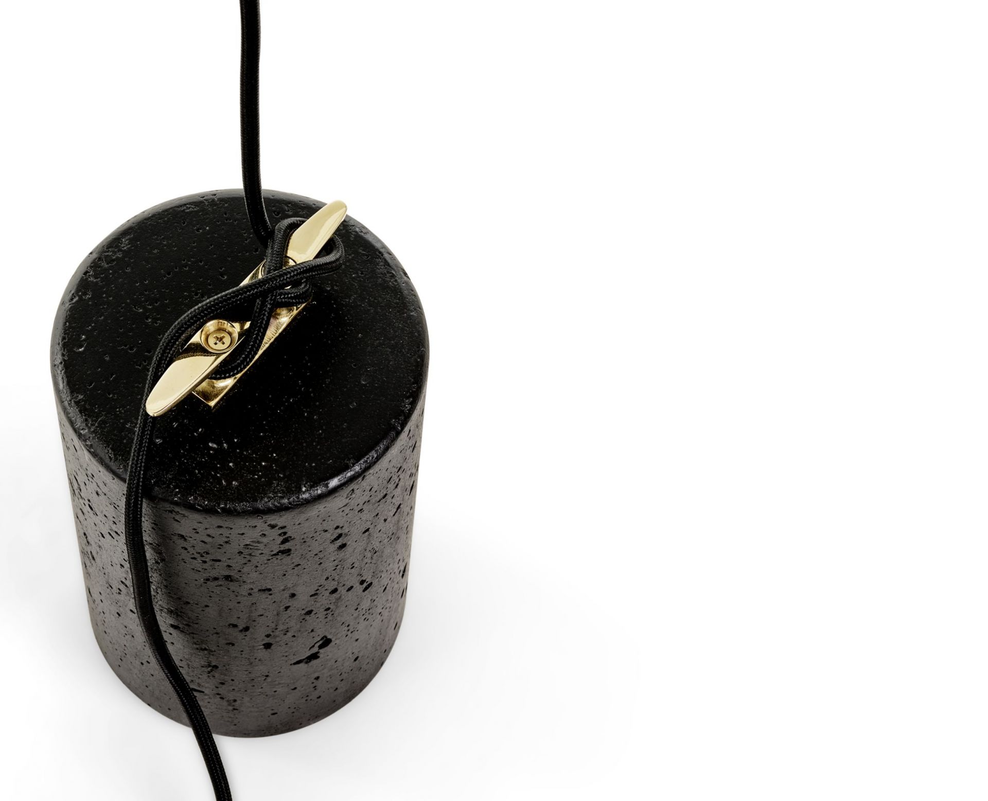 Nahaufnahme der Bitta Hängelampe von Mogg: Betonfuß mit goldfarbener Kabelhalterung und schwarzem Kabel.